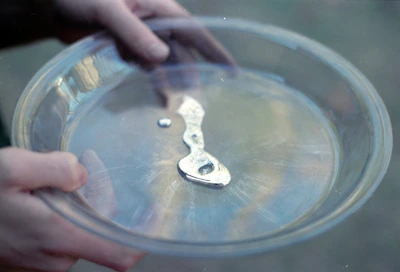 Liquid mercury in a clear glass dish.