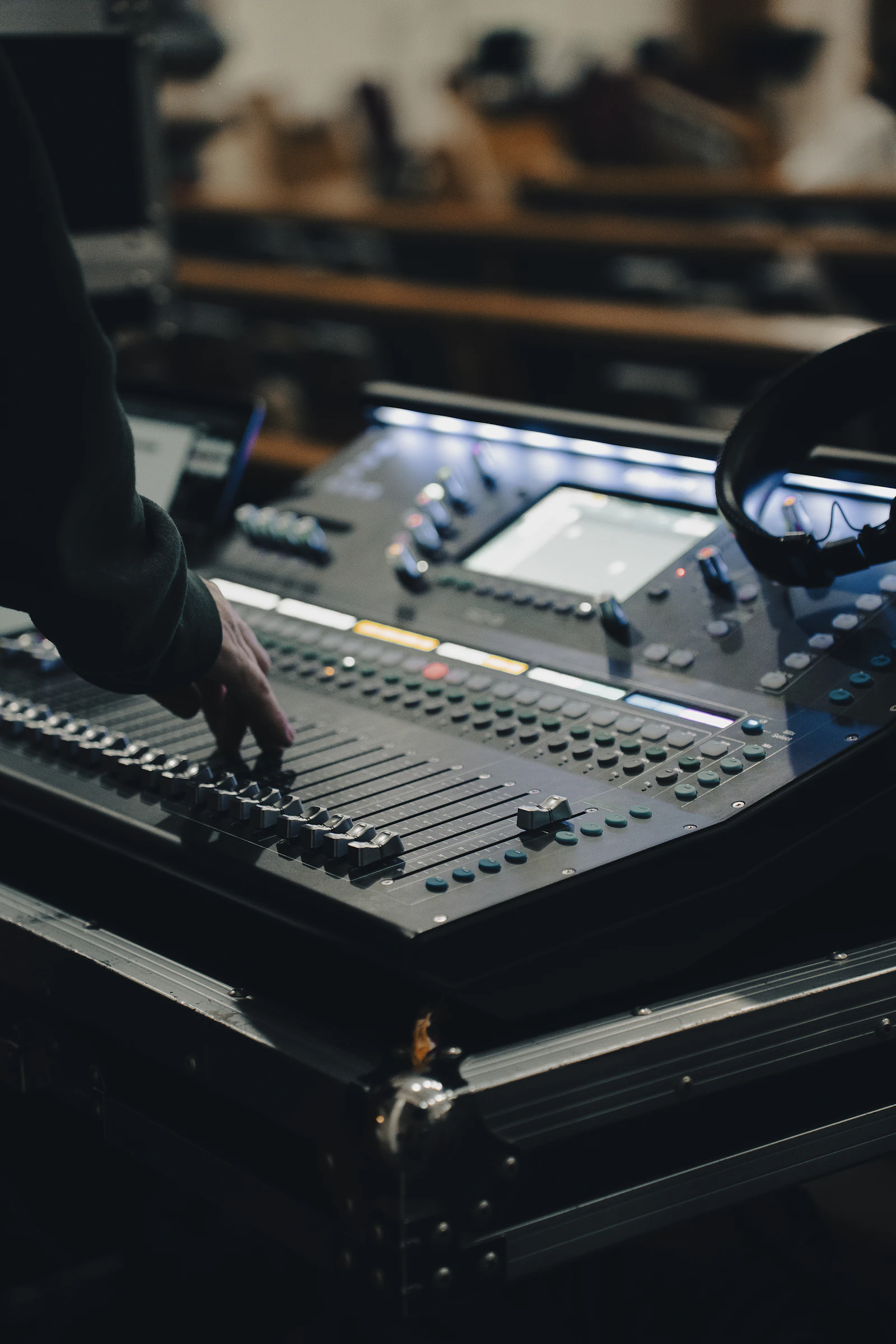 Illustrative photograph of an engineer adjusting an audio mixing desk