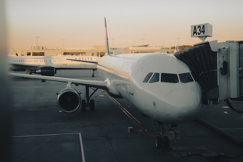 Airplane connected to a jet bridge at sunset