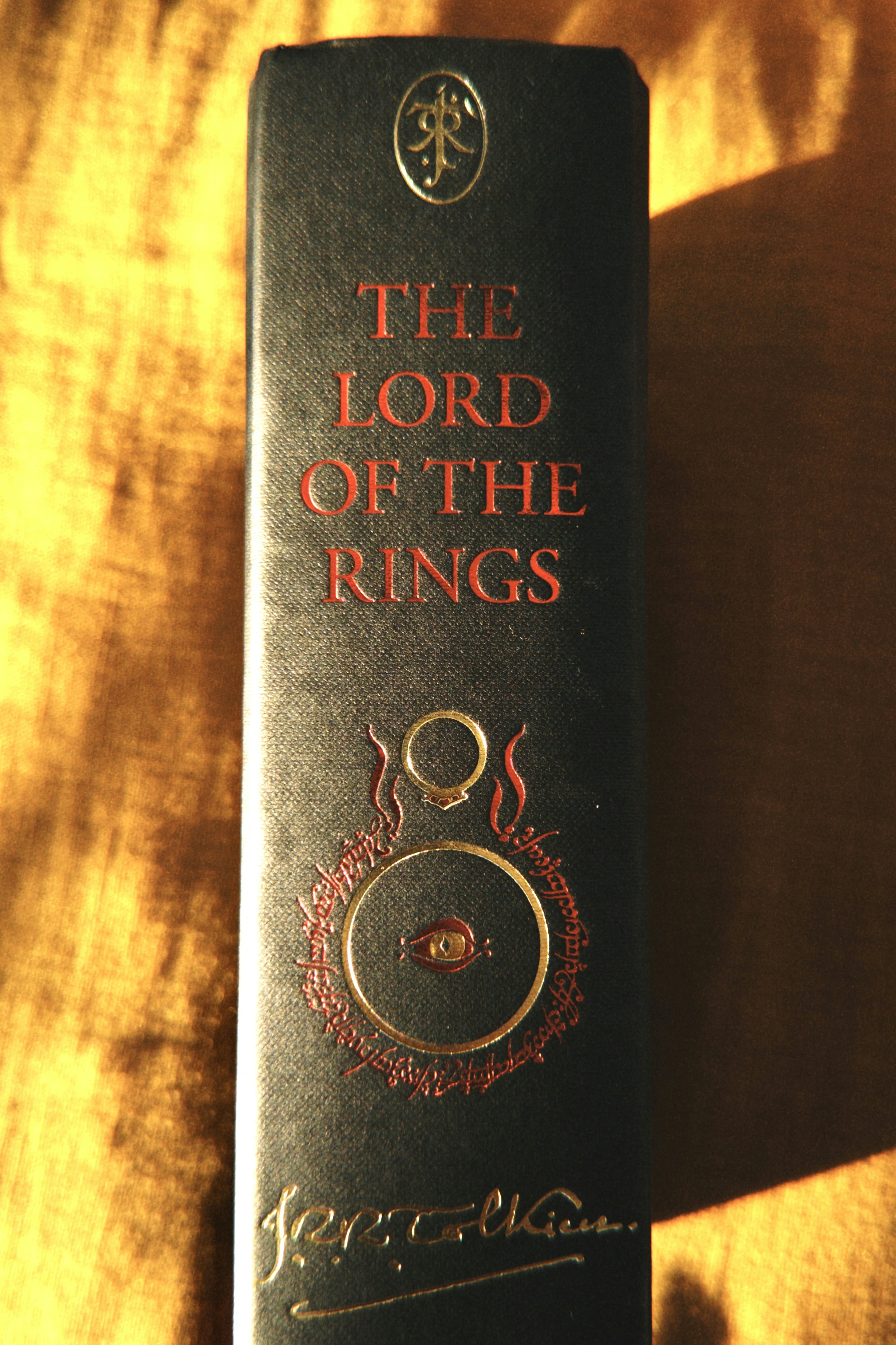 The lord of the rings book spine with gold emblem.