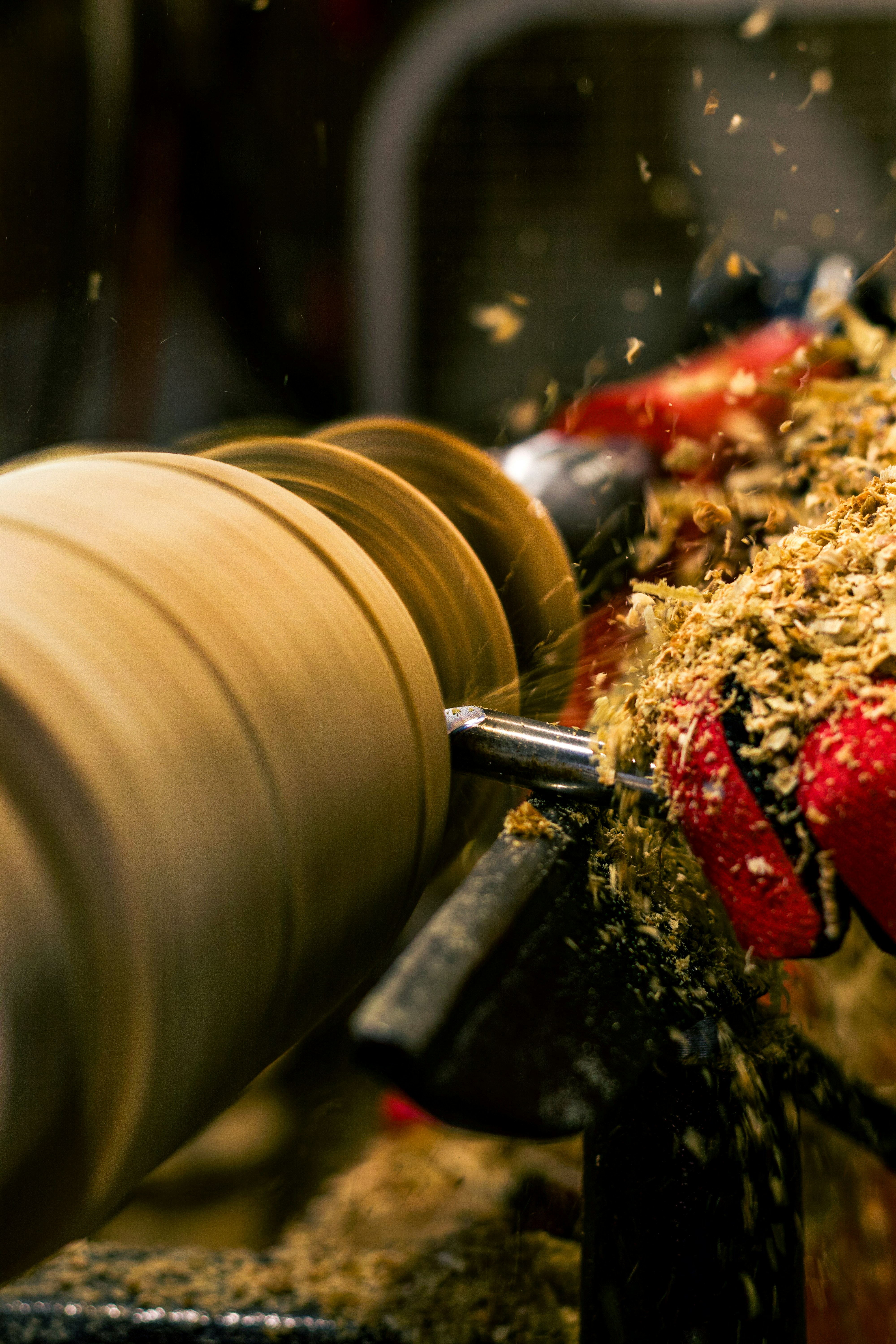 Woodturning with shavings flying off a lathe.