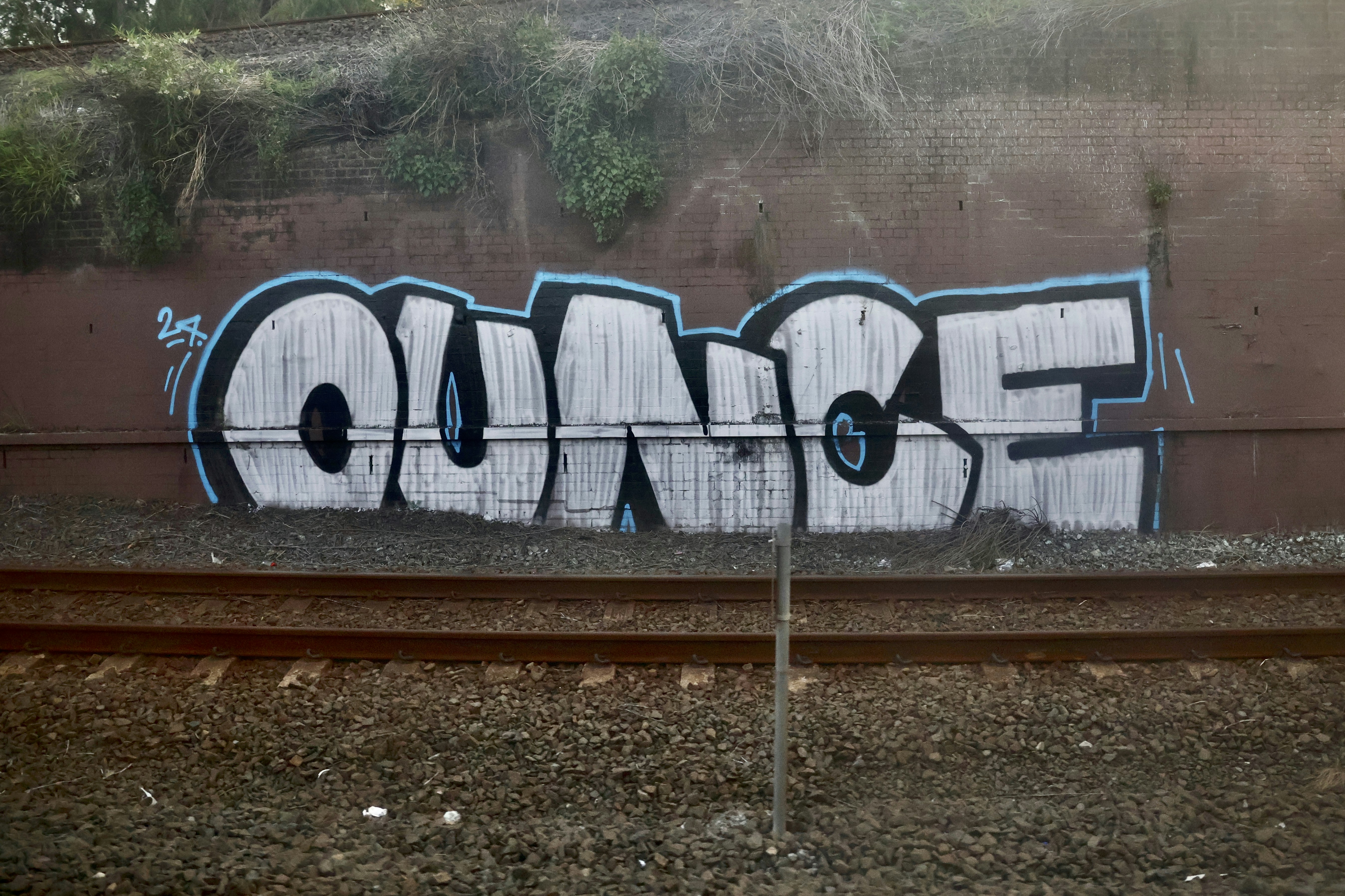 Graffiti art on a wall above train tracks