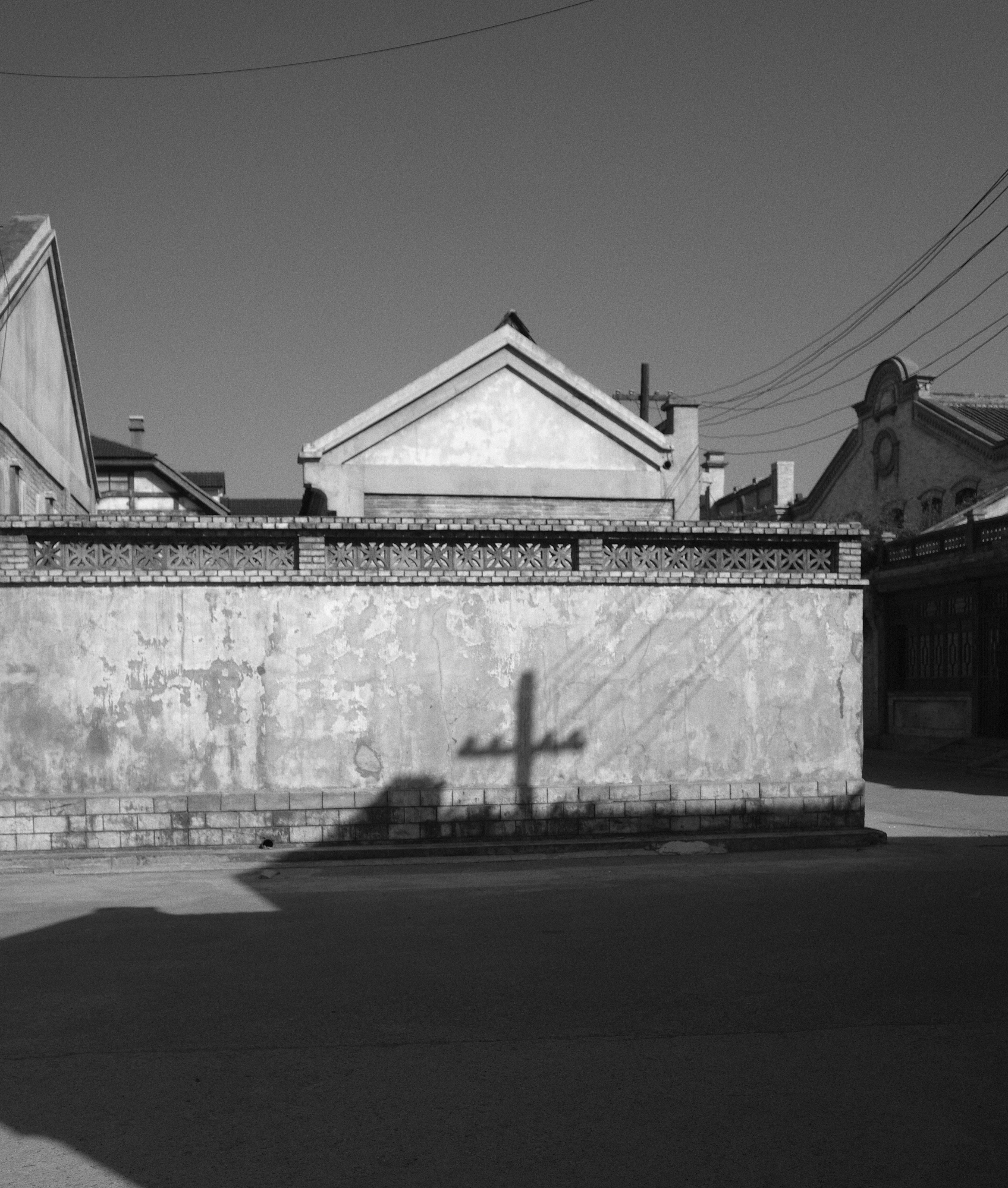Shadow of a cross on a weathered wall