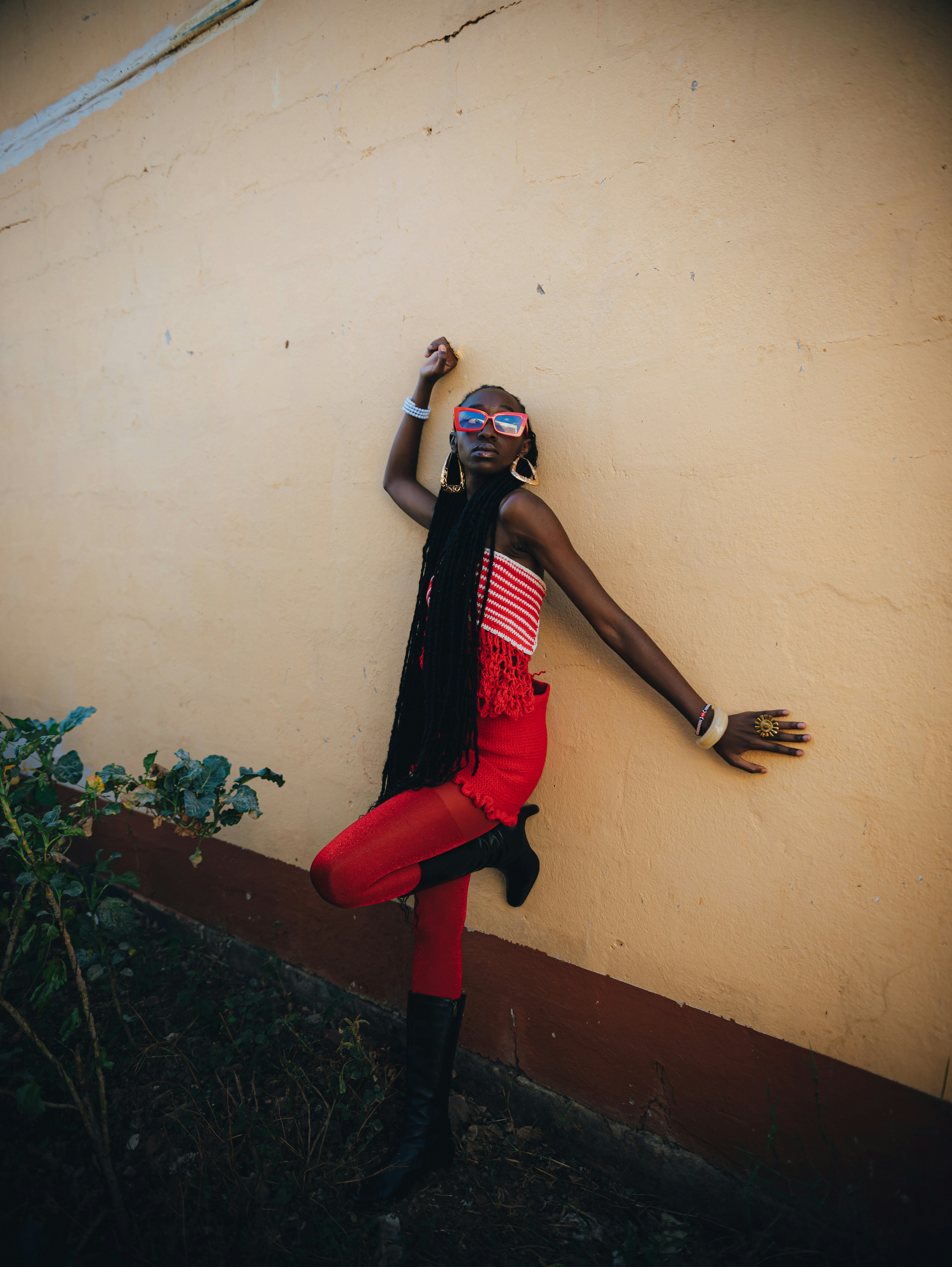 Uma mulher estilosa posa contra uma parede cor creme.