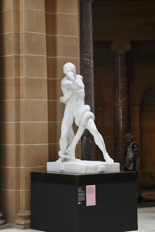 Marble sculpture of two figures intertwined with a snake.