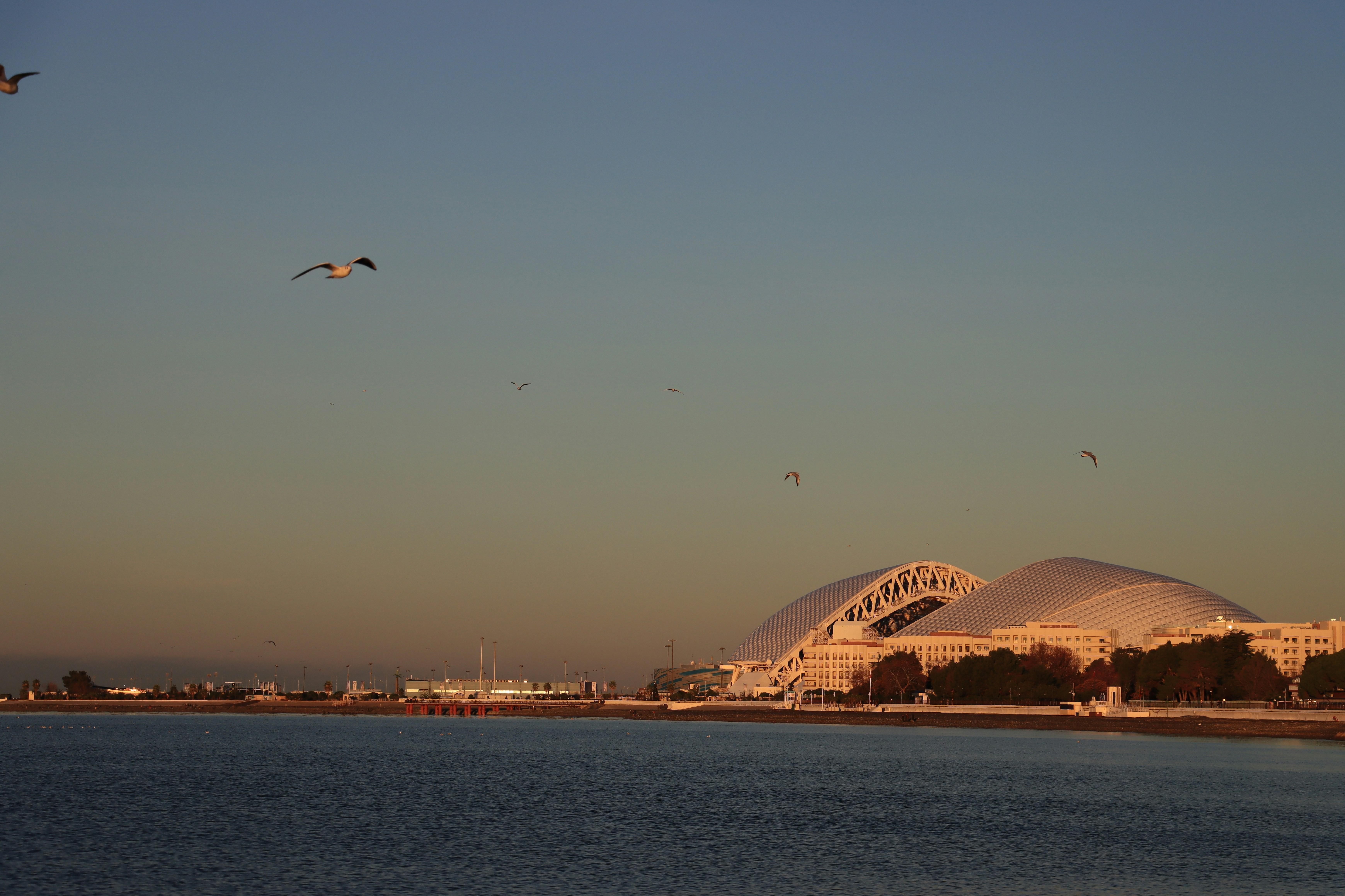 Edifici moderni lungo un tranquillo lungomare al tramonto.