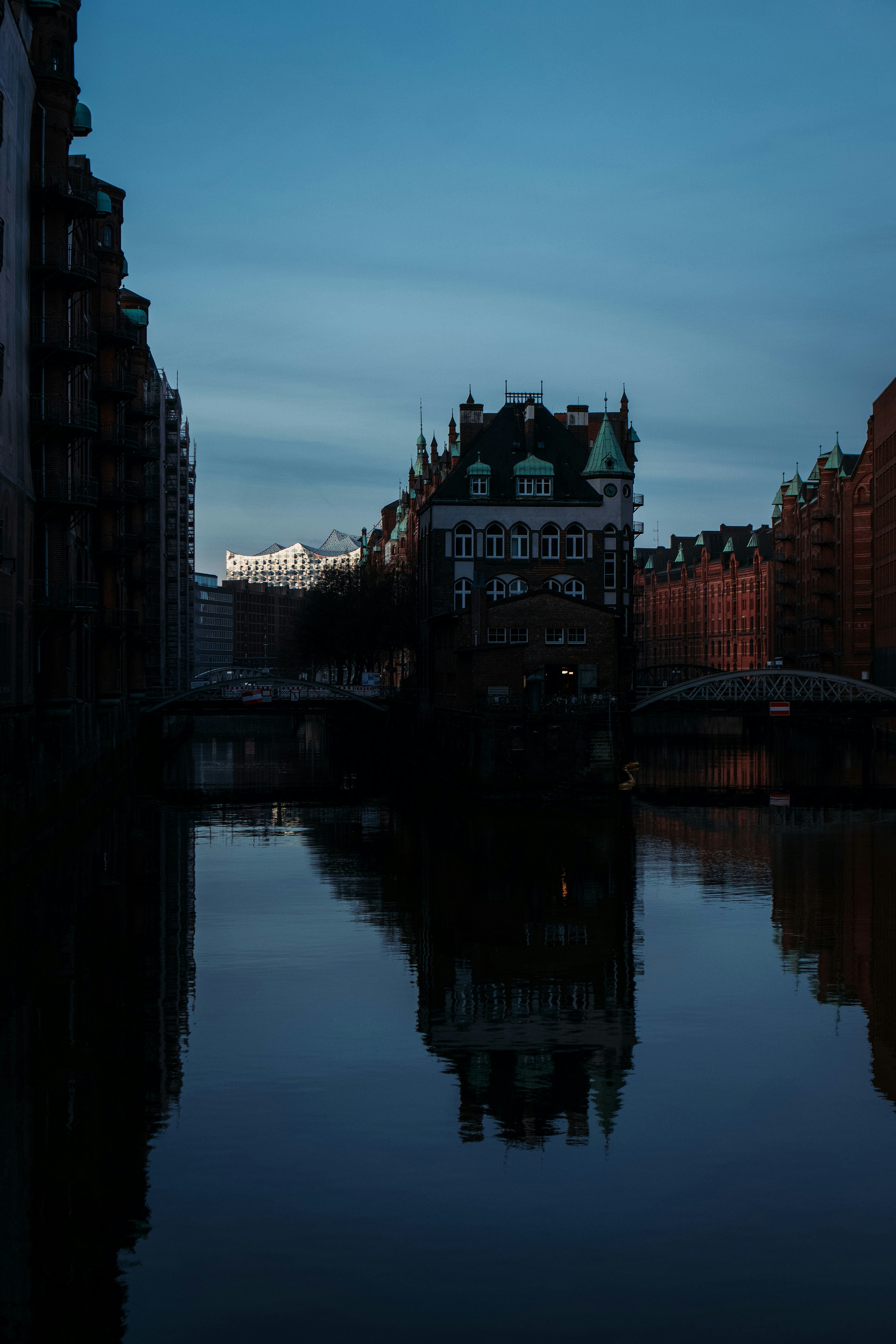 Buildings reflected in a calm canal at dusk