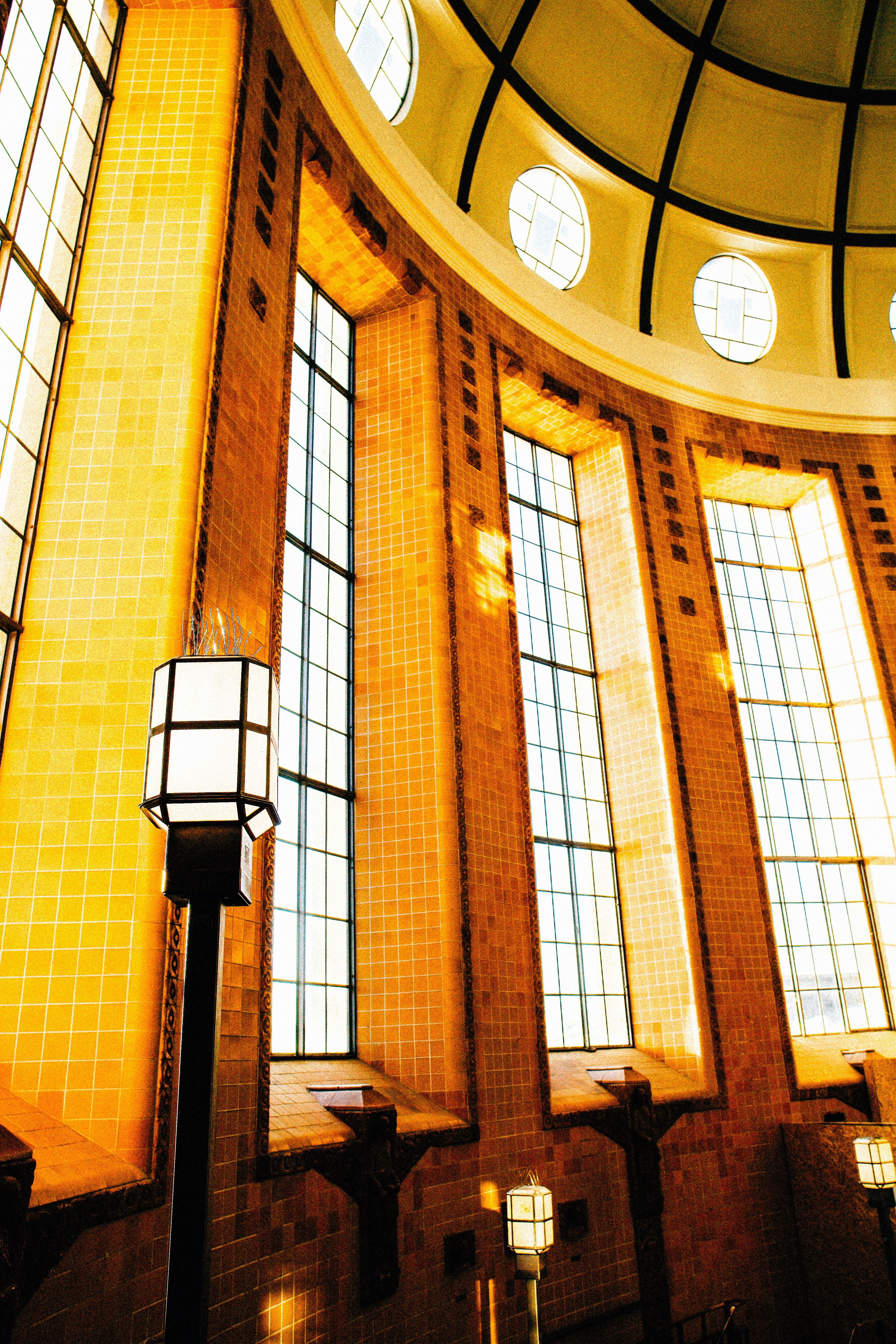 Sunlight streams through tall windows in domed building