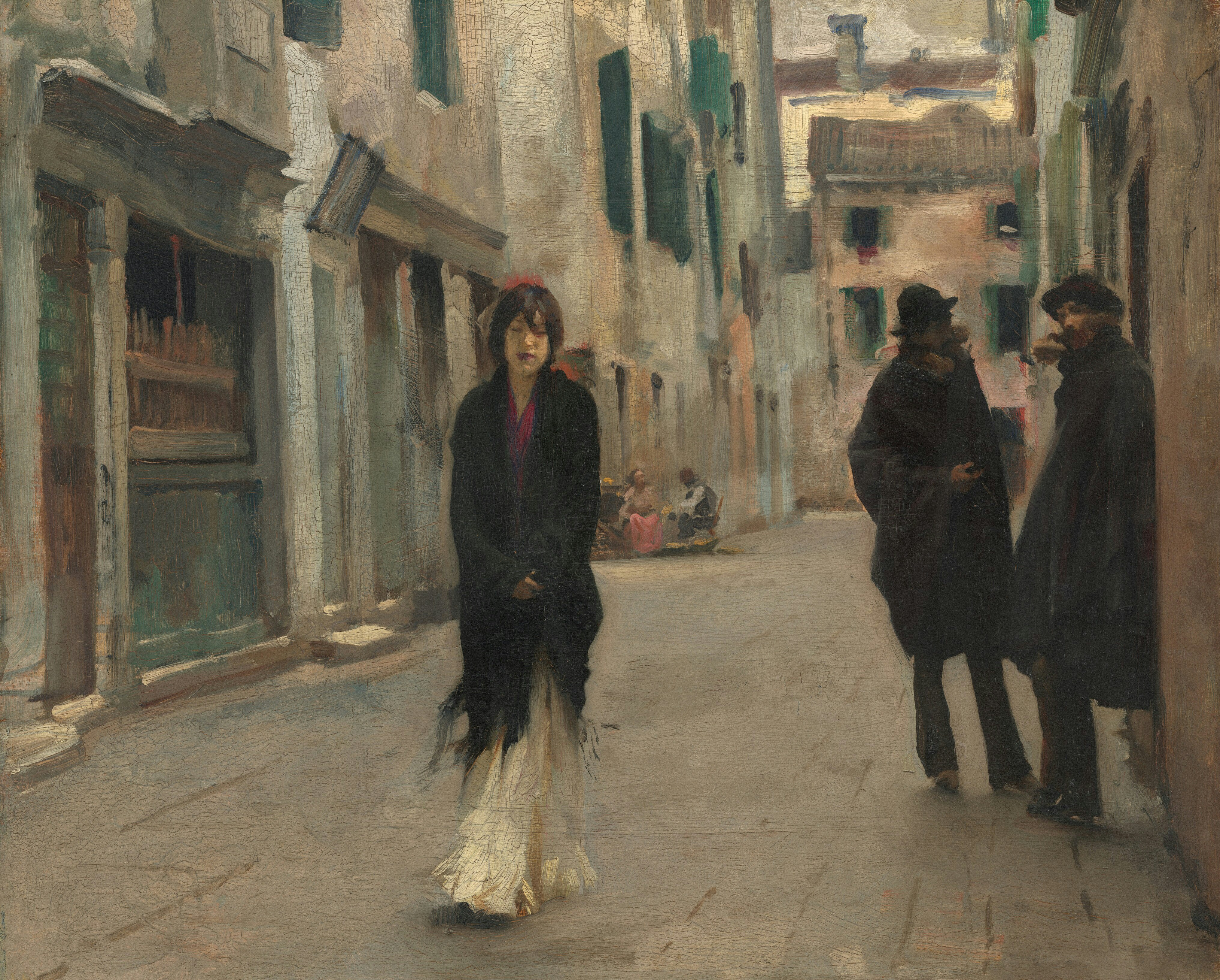 Frau, die eine schmale europäische Straße entlanggeht.