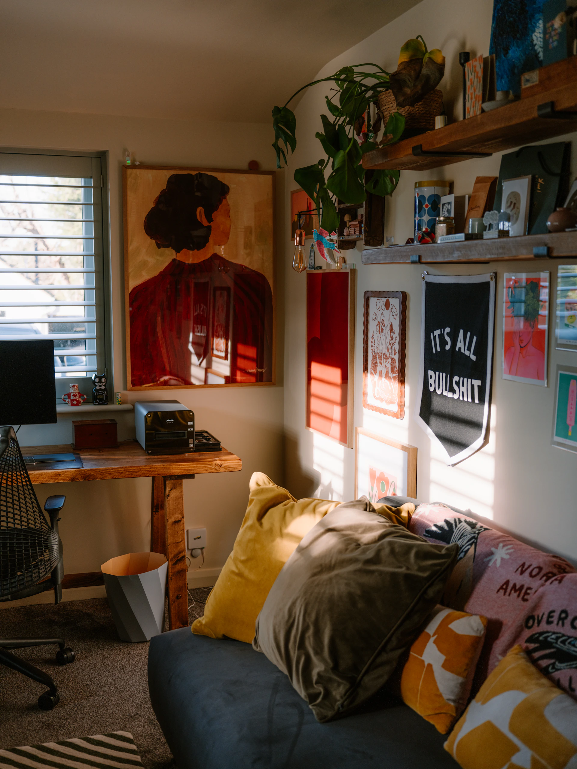 Sunlight streams into a cozy room with art.