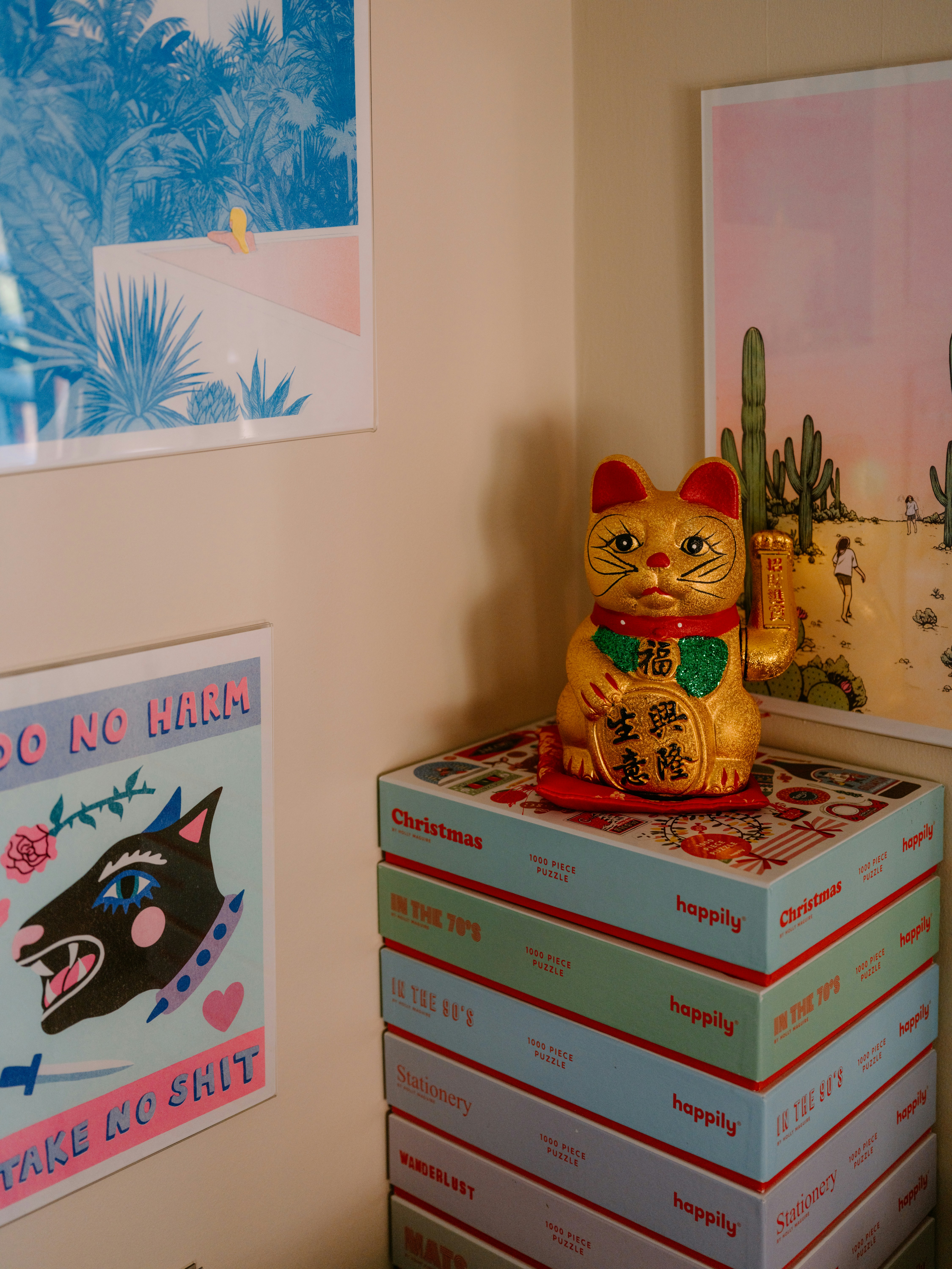 Golden lucky cat sits on stacked colorful boxes.