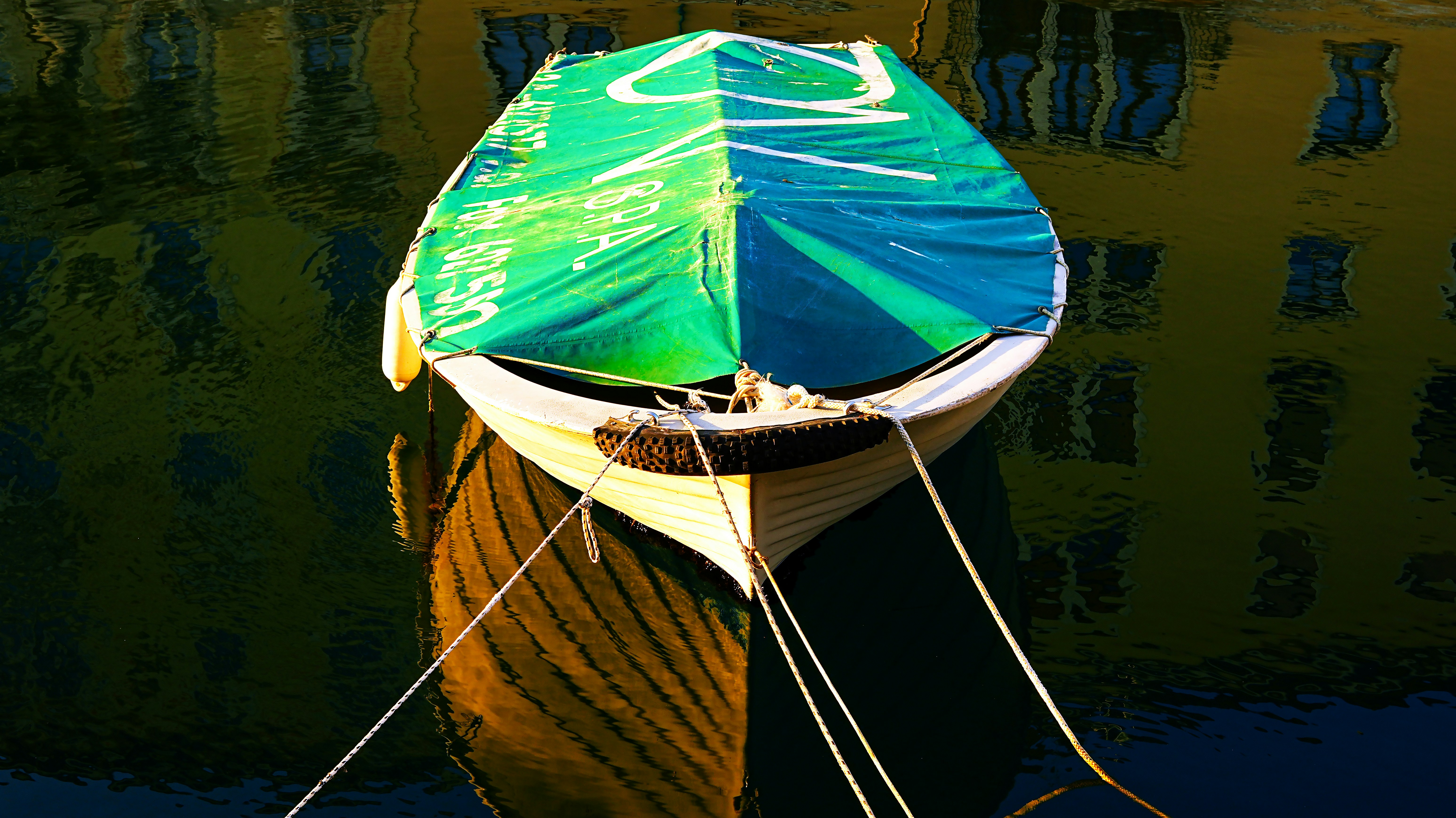 A colorful boat floats on calm water.