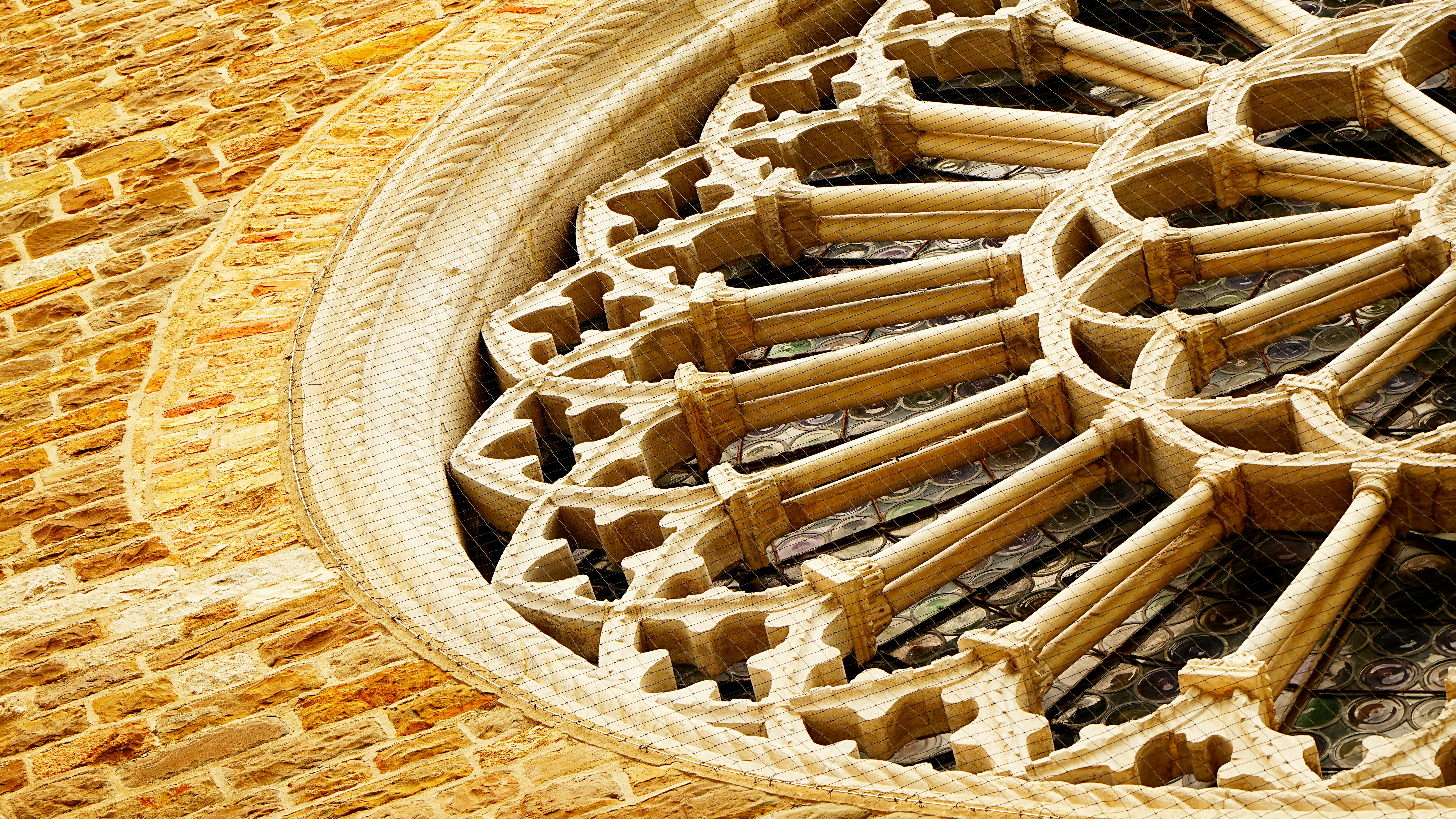 Intricate stone rose window on a brick building