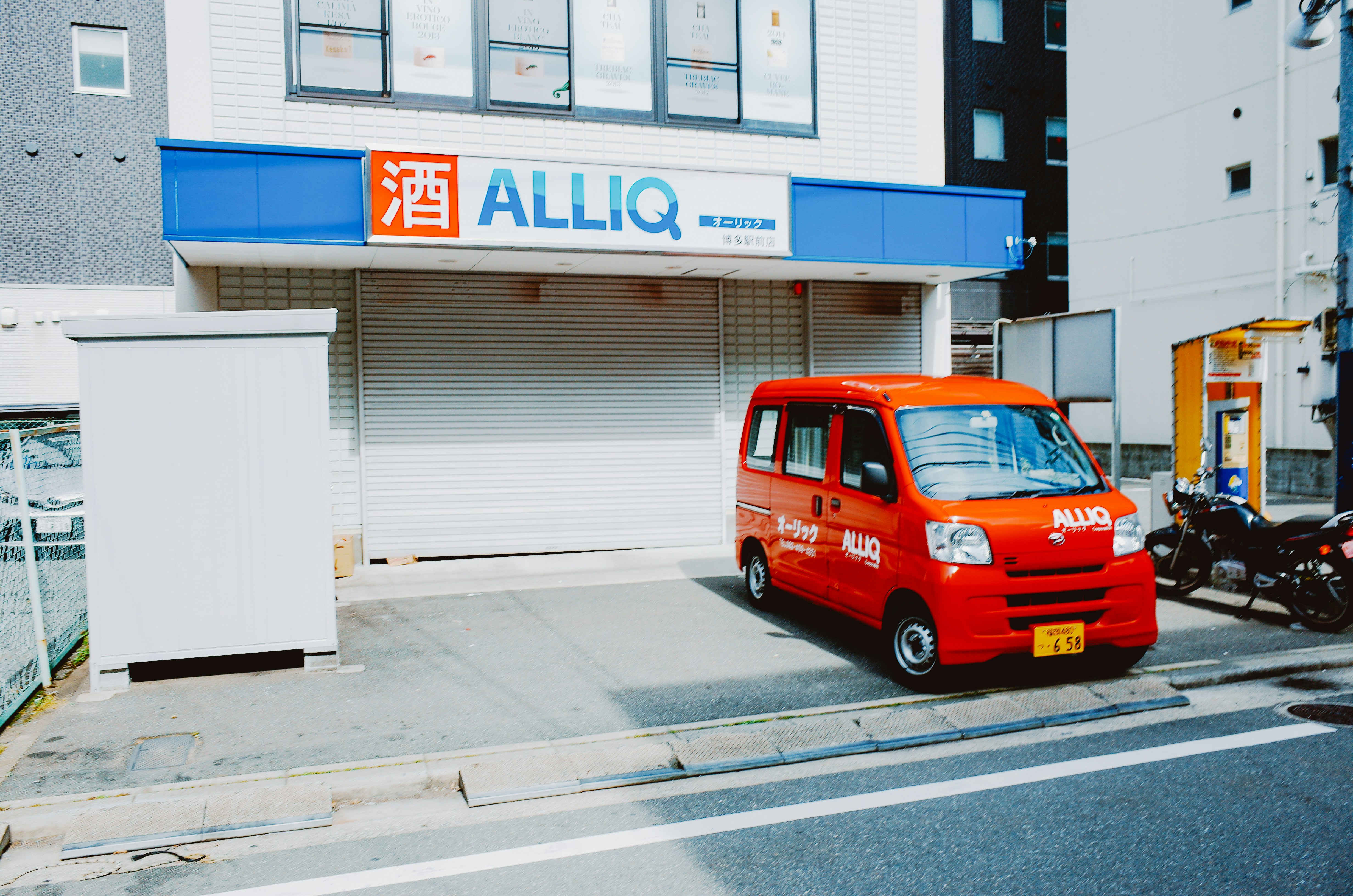 Red delivery van parked outside a store.