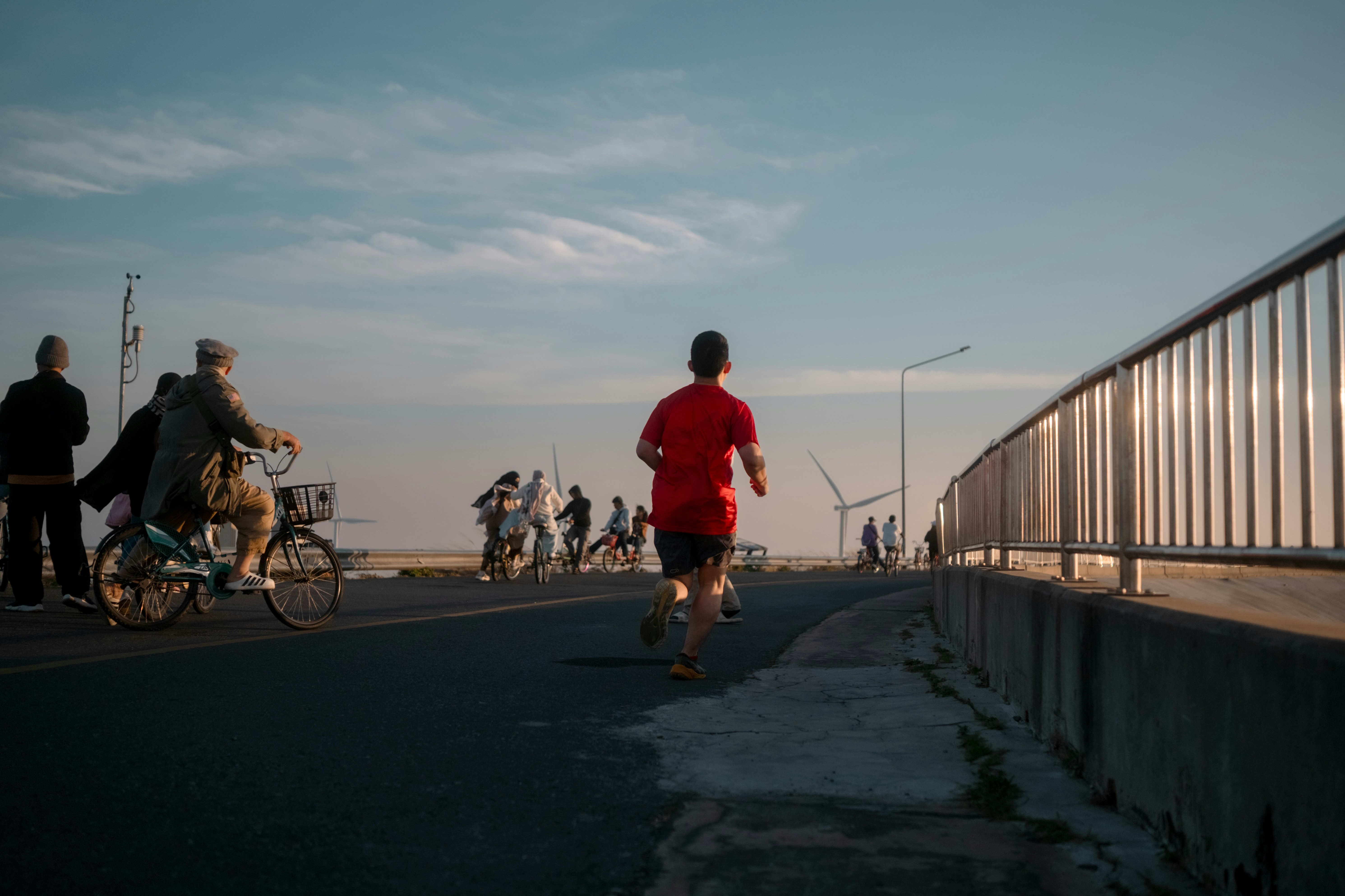 Man jogging on a sunny day with people around.
