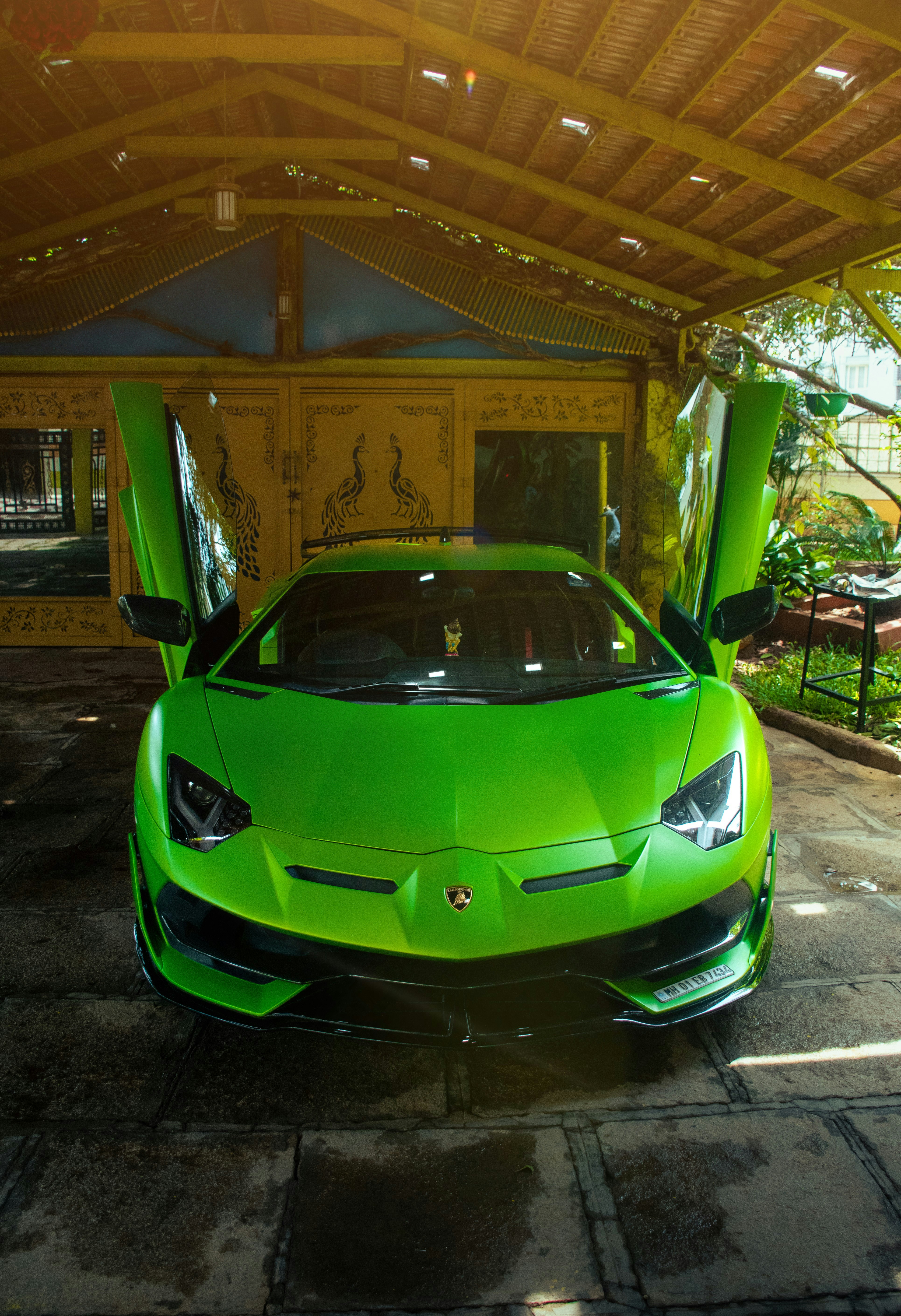 Une Lamborghini vert vif avec les portes ouvertes.