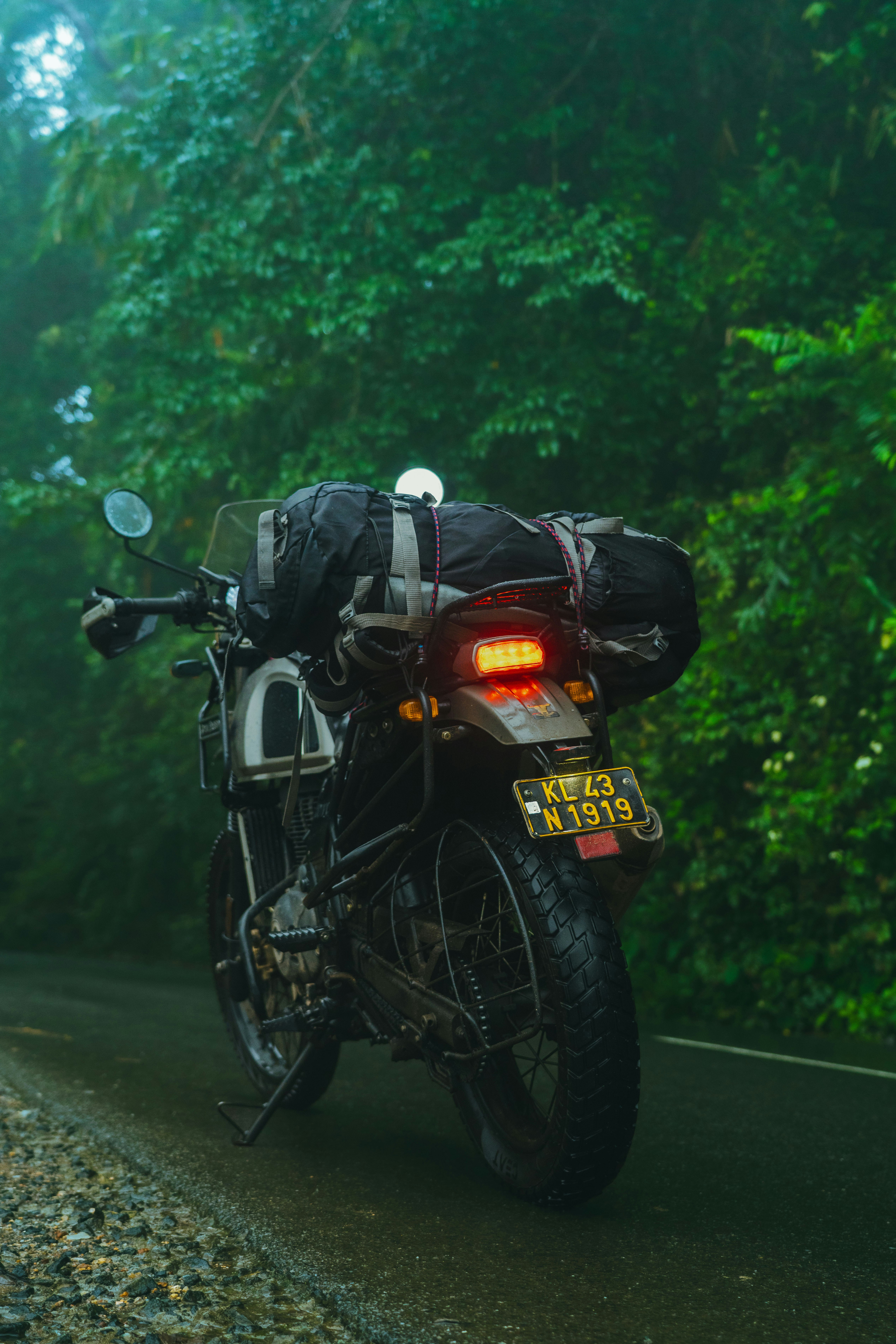 Motorcycle loaded with luggage on a wet road.