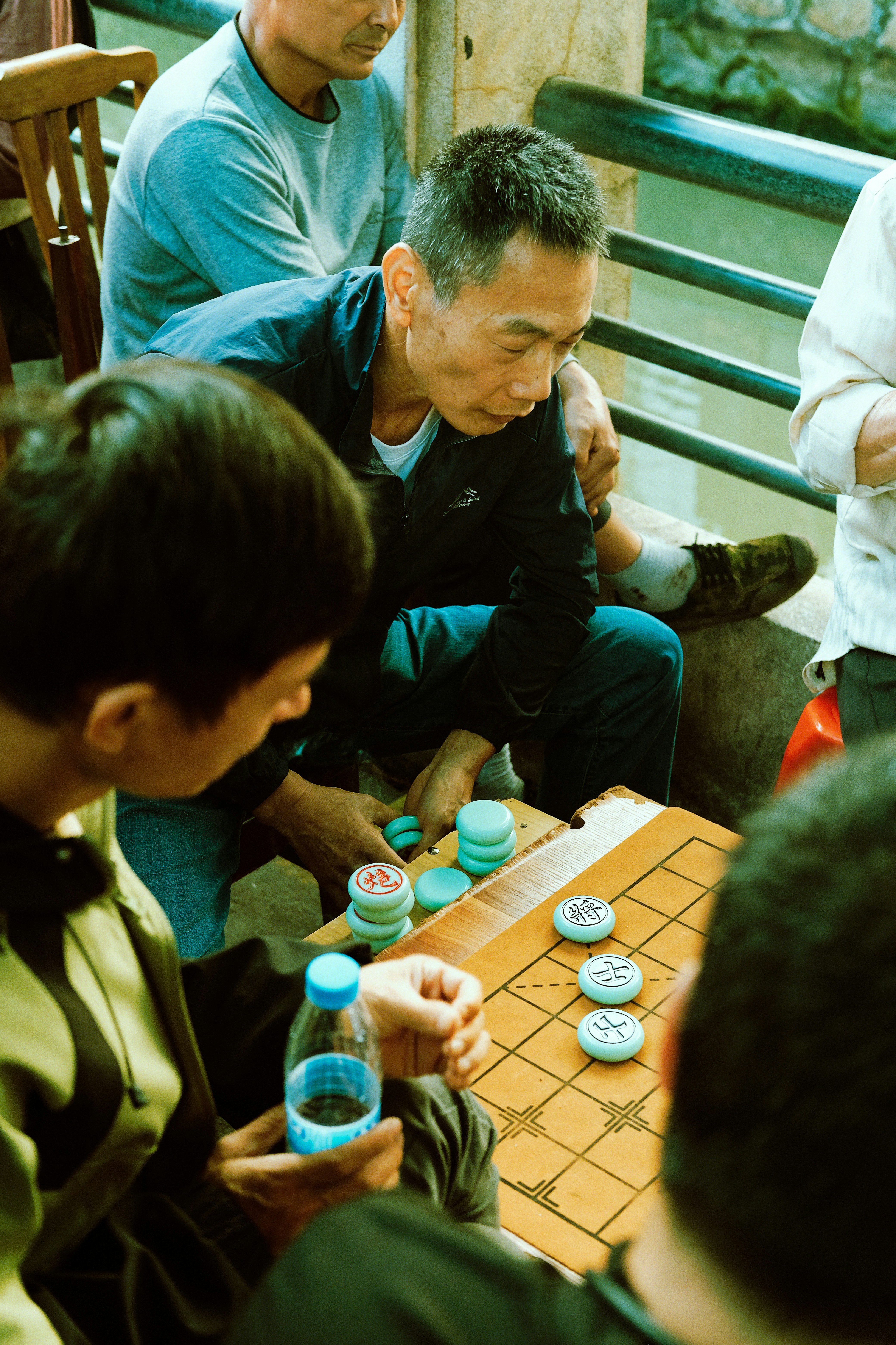 Men playing chinese chess by the water
