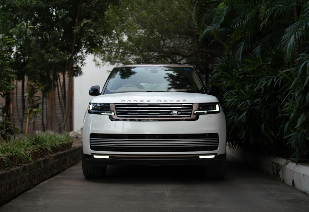 Balts Range Rover uz bruģēta piebraucamā ceļa