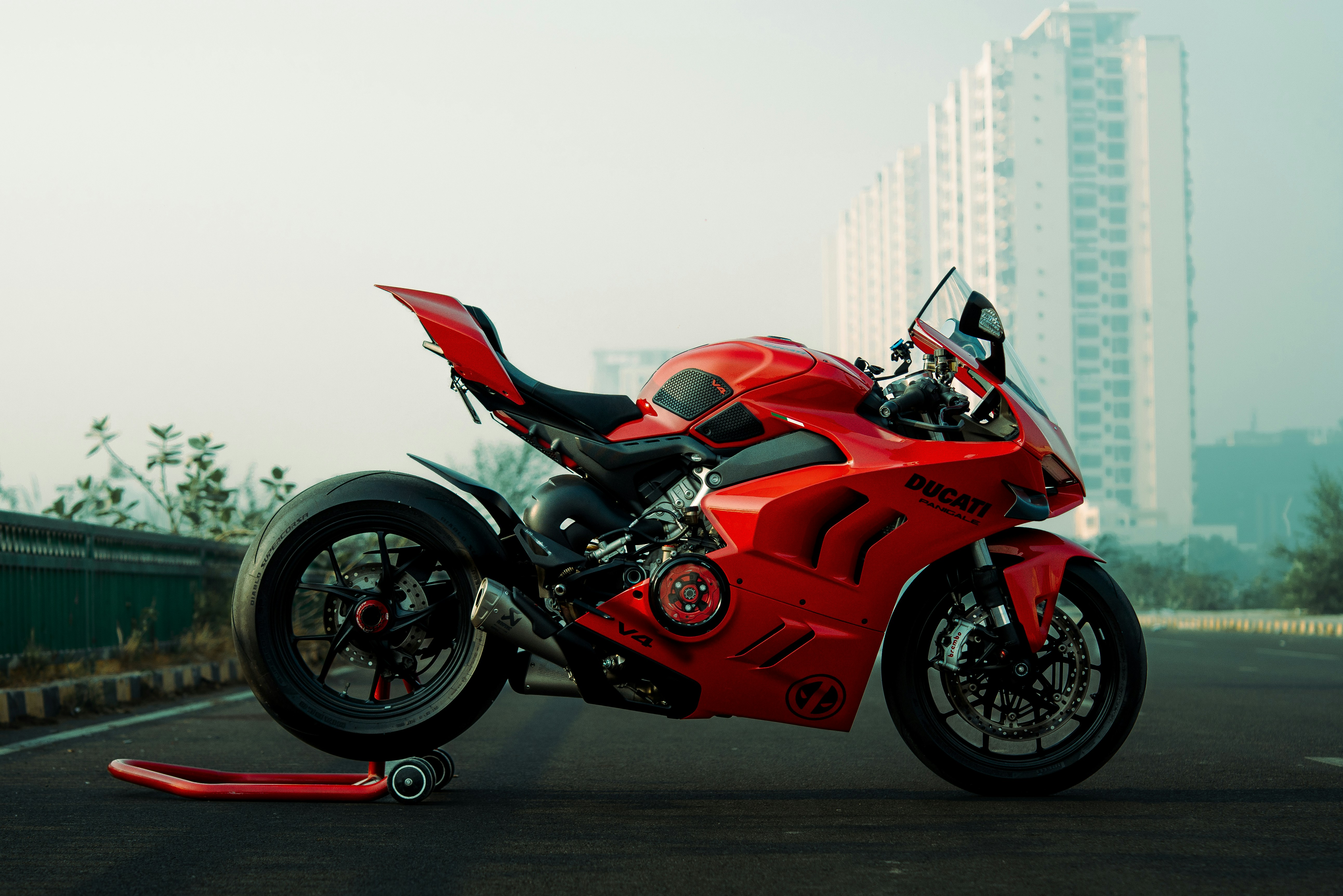 Red sport motorcycle parked on asphalt road.