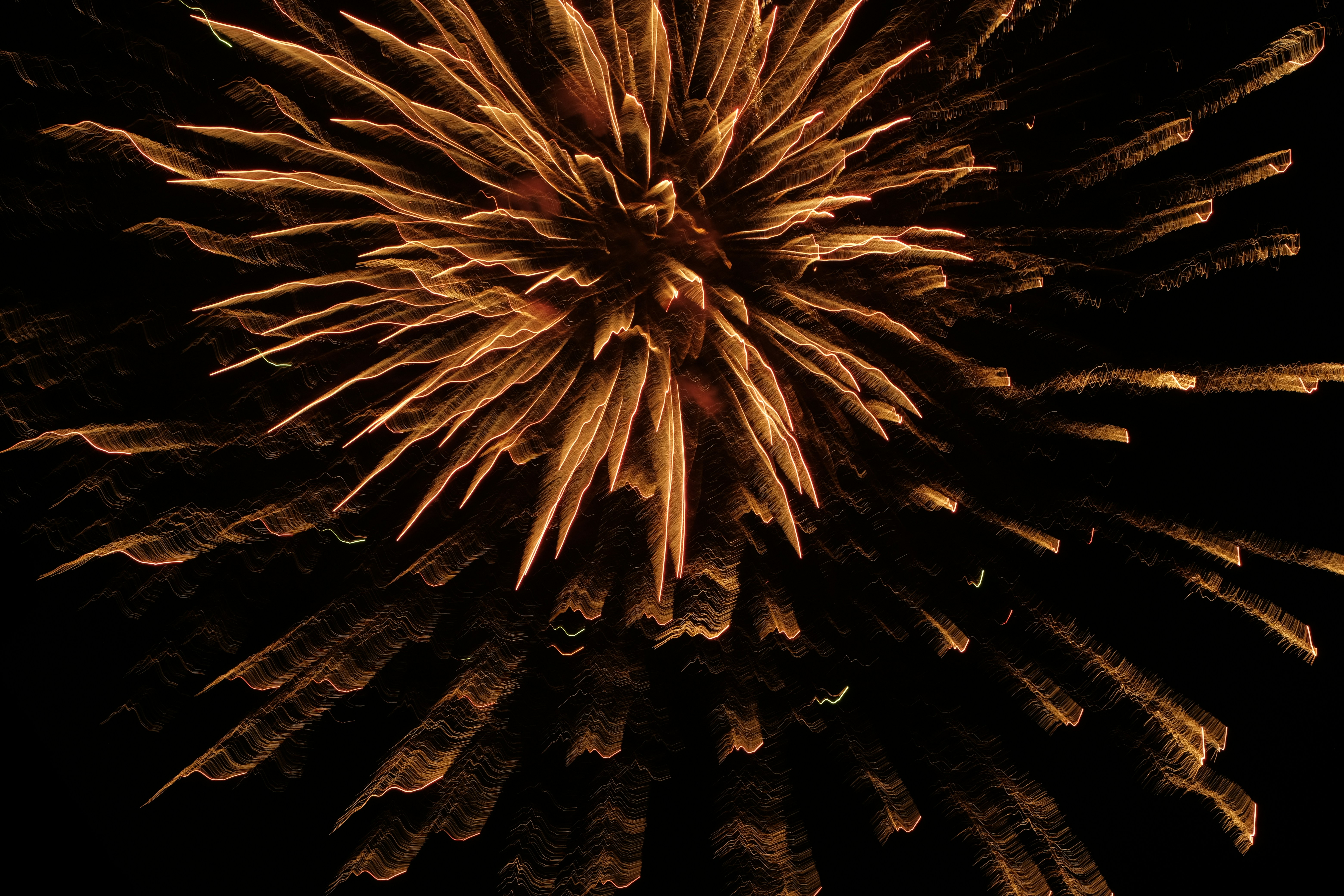 Golden fireworks exploding in the night sky