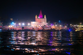 Temple illuminated at night with reflections on water