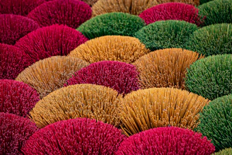 Colorful bundles of dried grass arranged closely together.
