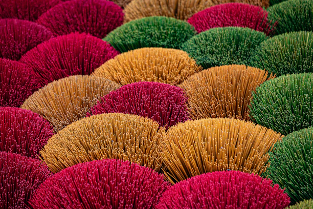 Colorful bundles of dried grass arranged closely together.