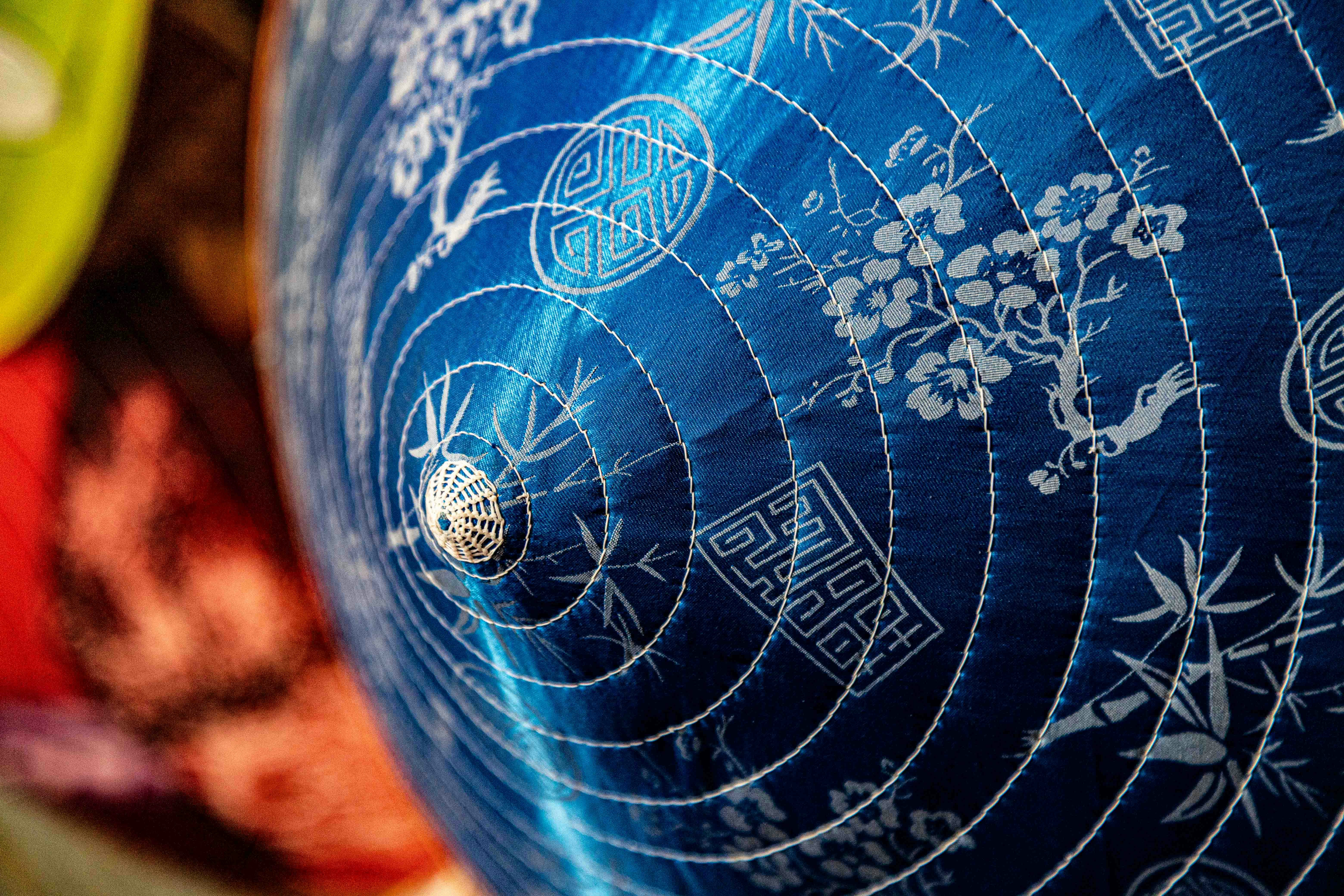 Blue conical hat with white intricate patterns