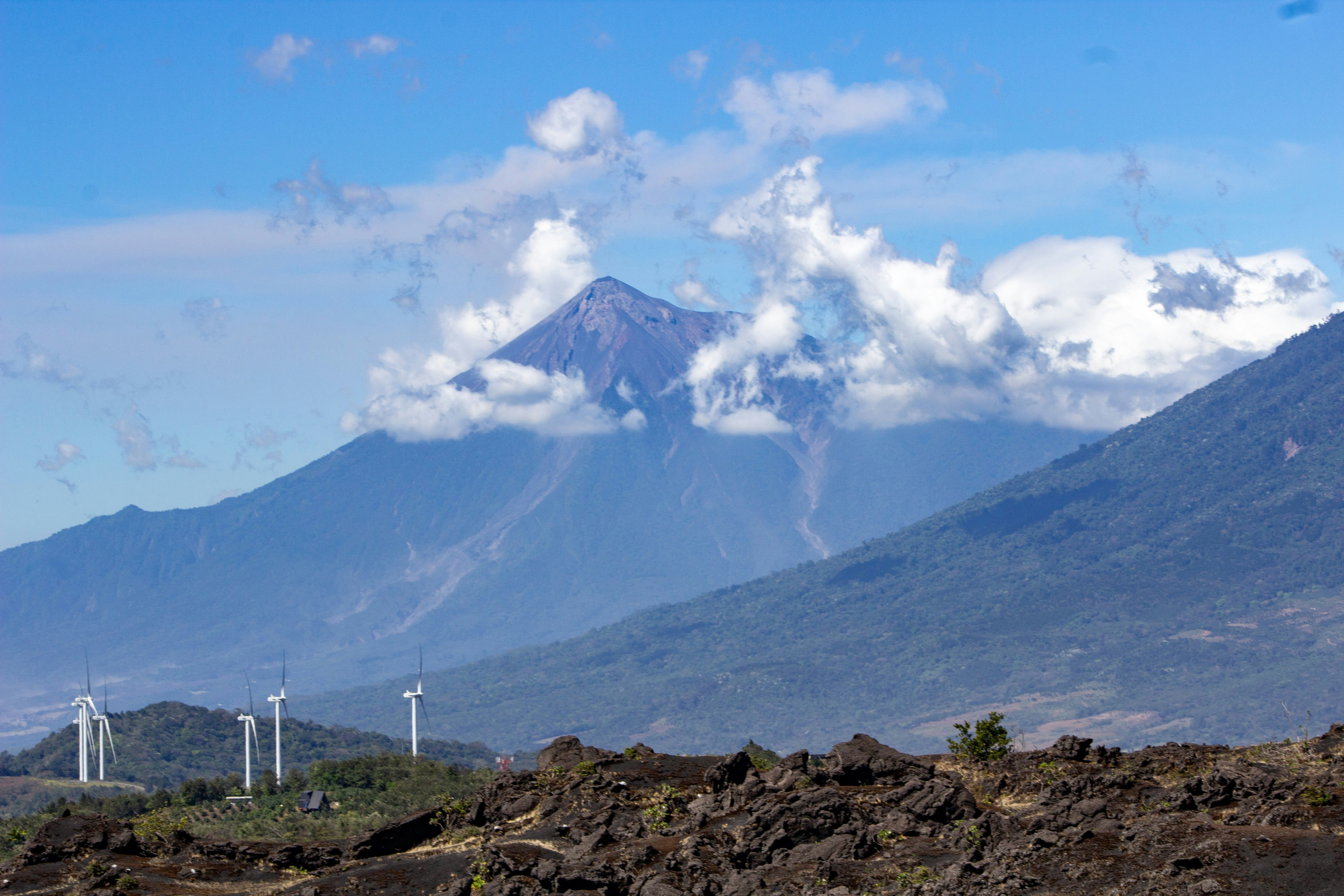 Wind turbines in front of a cloudy mountain range