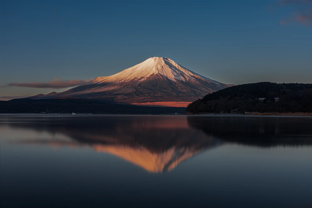 Mount Fuji reflected in a calm lake at sunrise