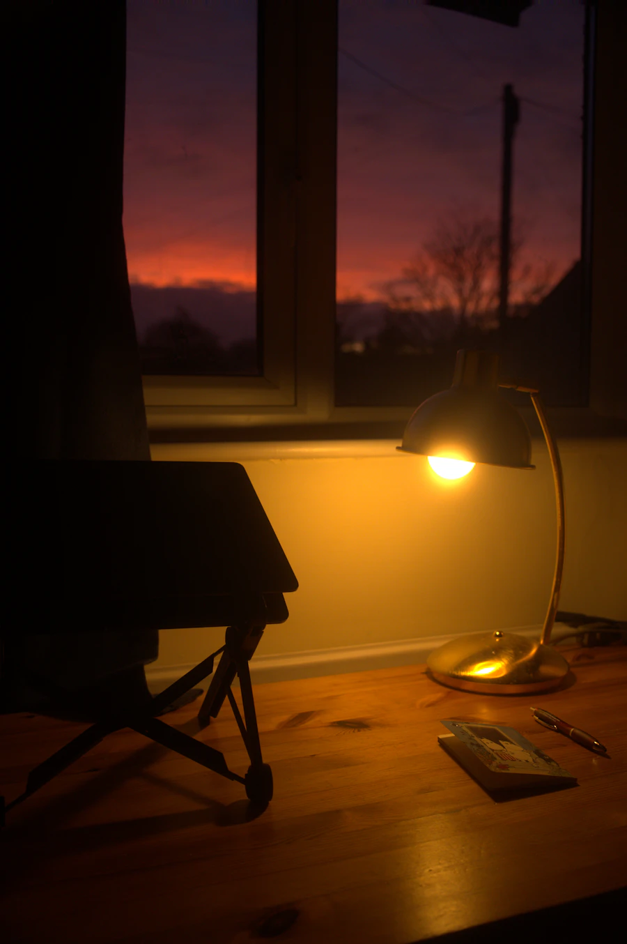A quiet desk near a window in warm evening light