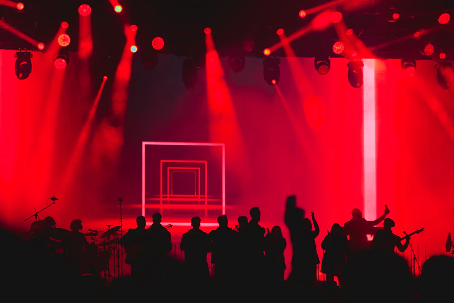 Stage with red dramatic lighting and a silhouetted crowd in fog