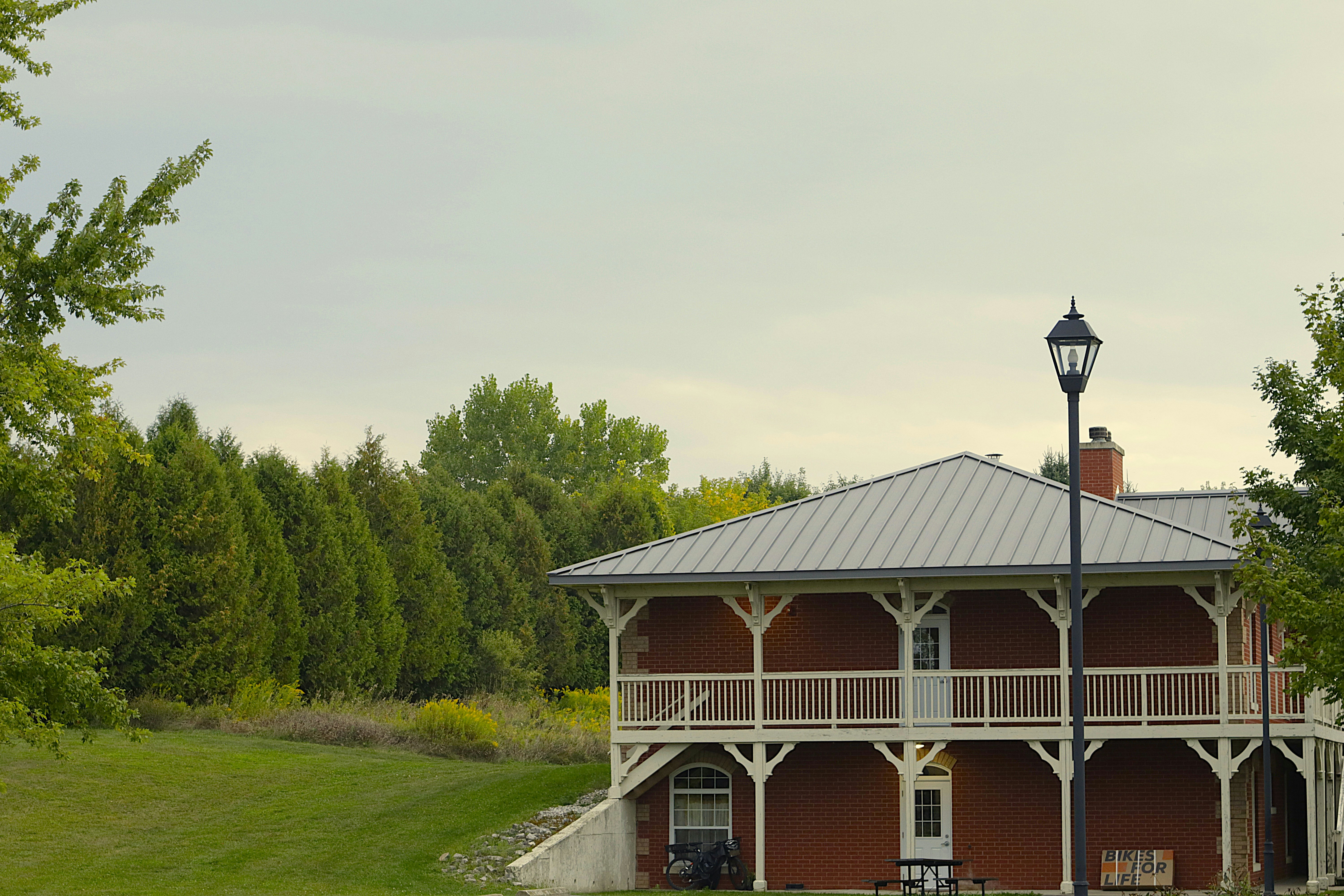 Casa in mattoni rossi con balconi bianchi e un lampione.