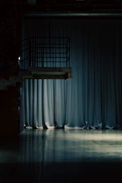A diving platform over a reflective floor and curtains