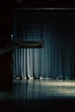 A diving platform over a reflective floor and curtains