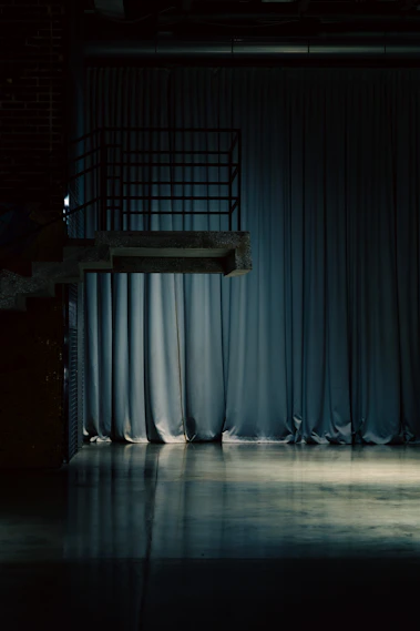 A diving platform over a reflective floor and curtains