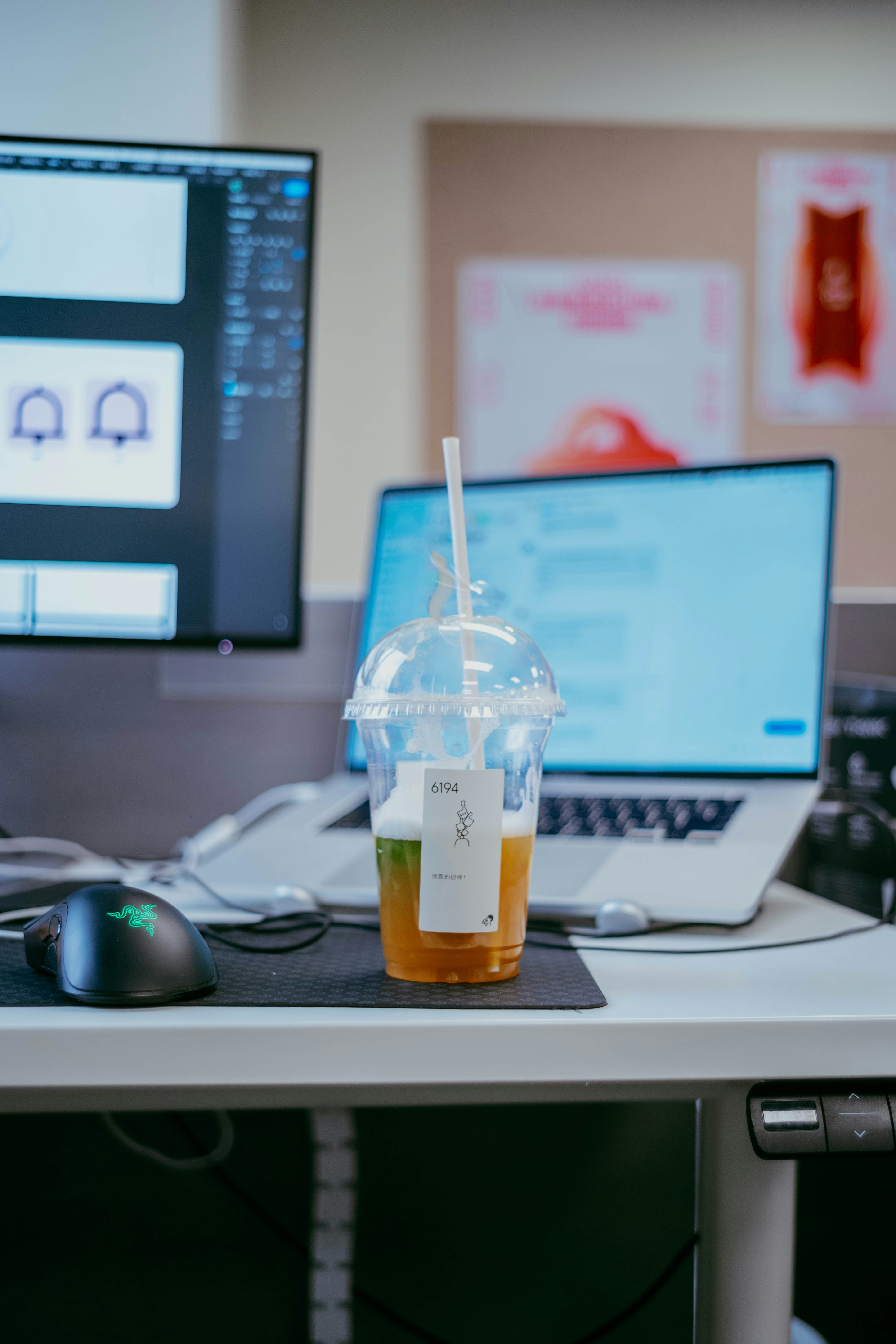 A cold drink with a straw on a desk.