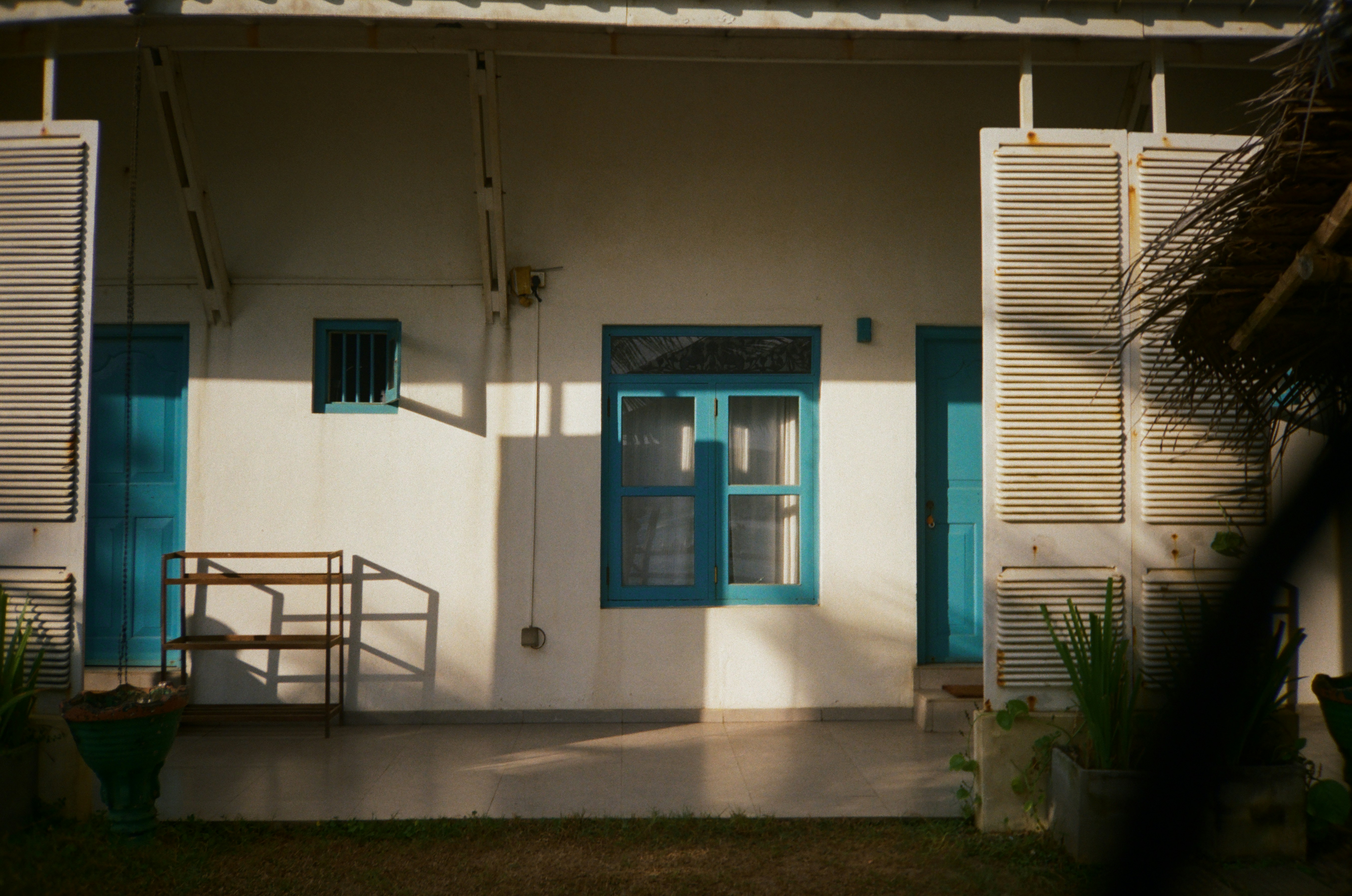 Weißes Gebäude mit blauen Fenstern und Fensterläden