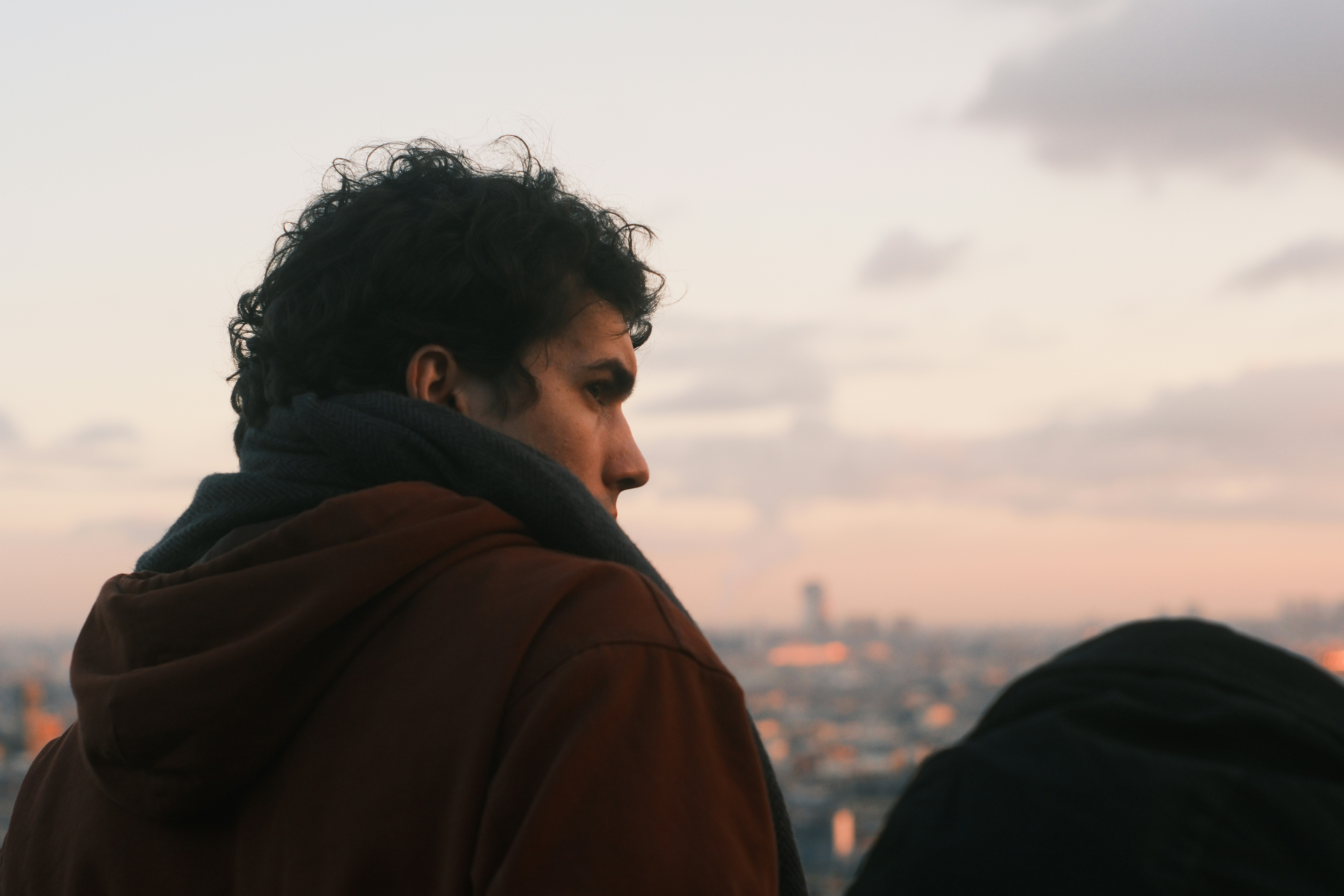 Man looking out over a city at dusk