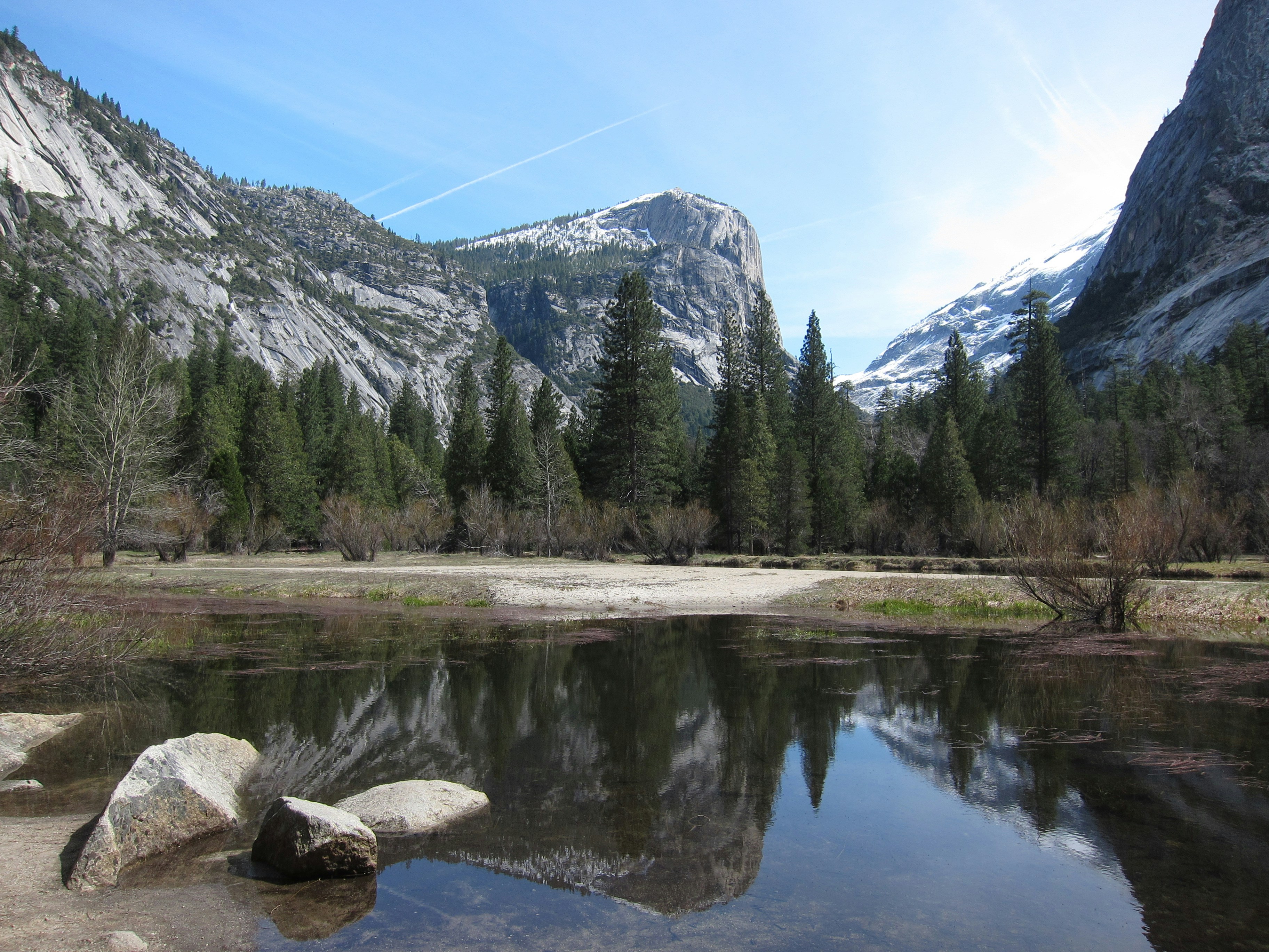 Mountain landscape with a reflective lake and evergreen trees