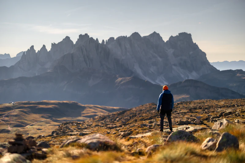 Hiker looking out at a majestic mountain range in Bolzano, Italy