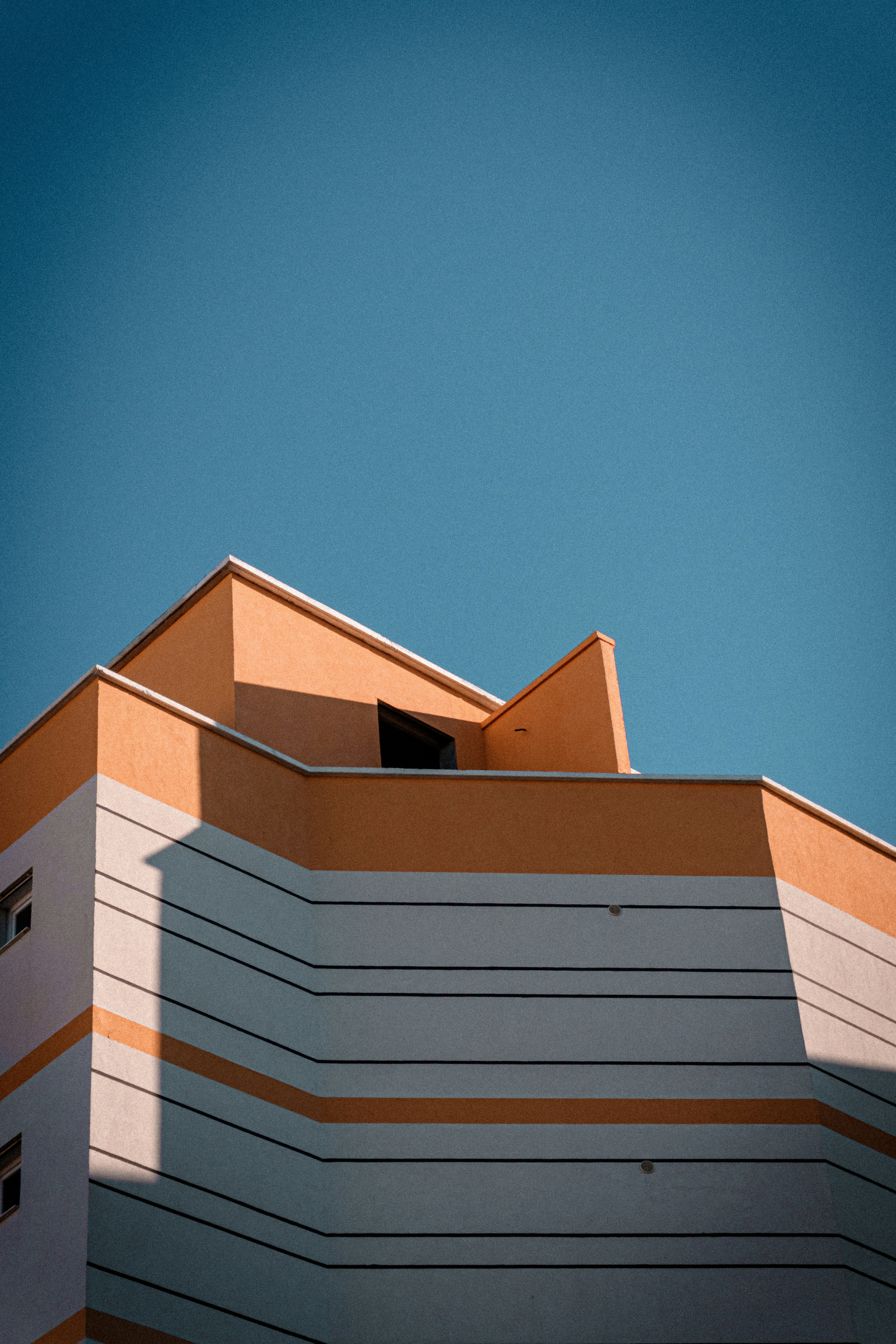 Modern building facade against a clear blue sky.