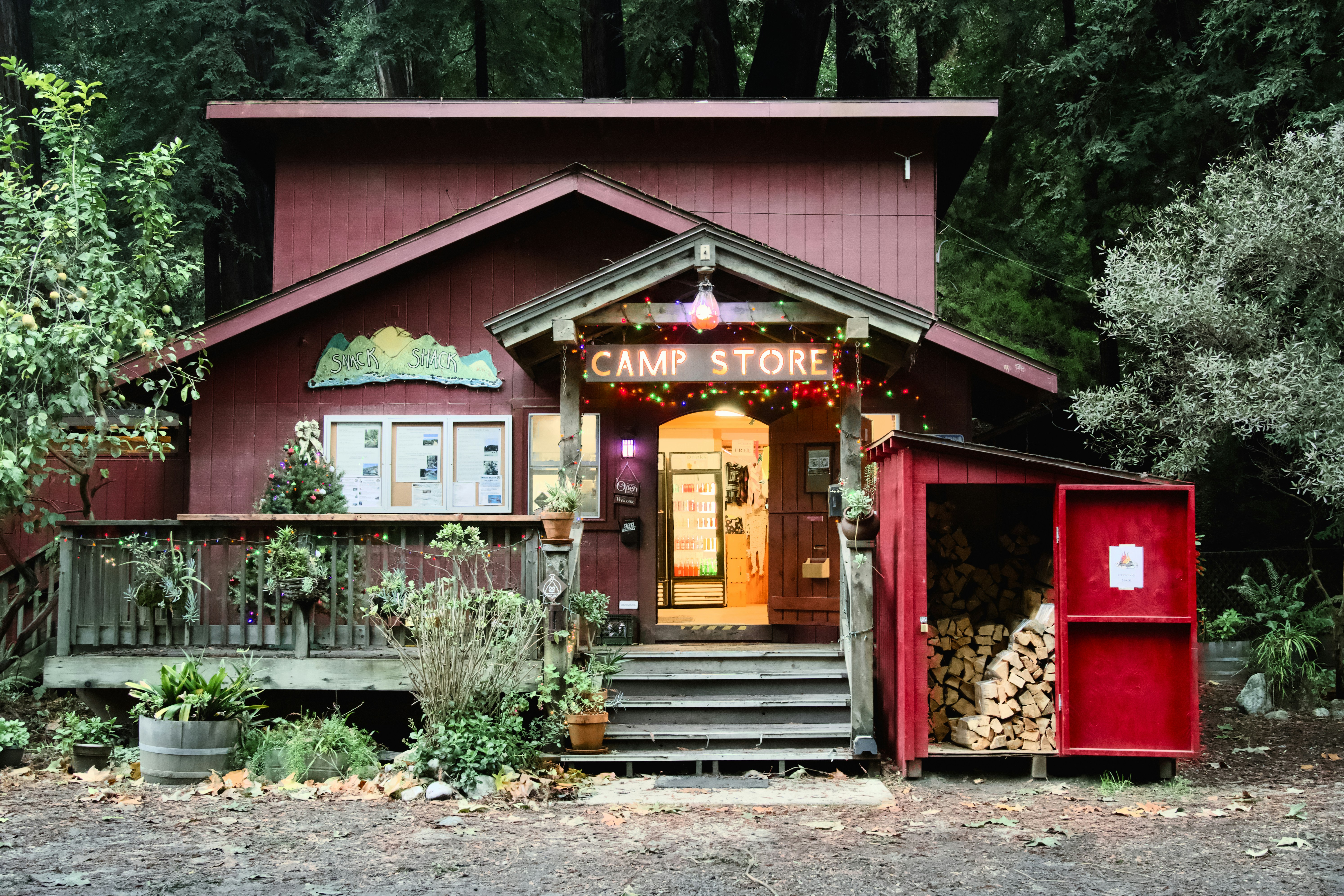 Red camp store building surrounded by trees