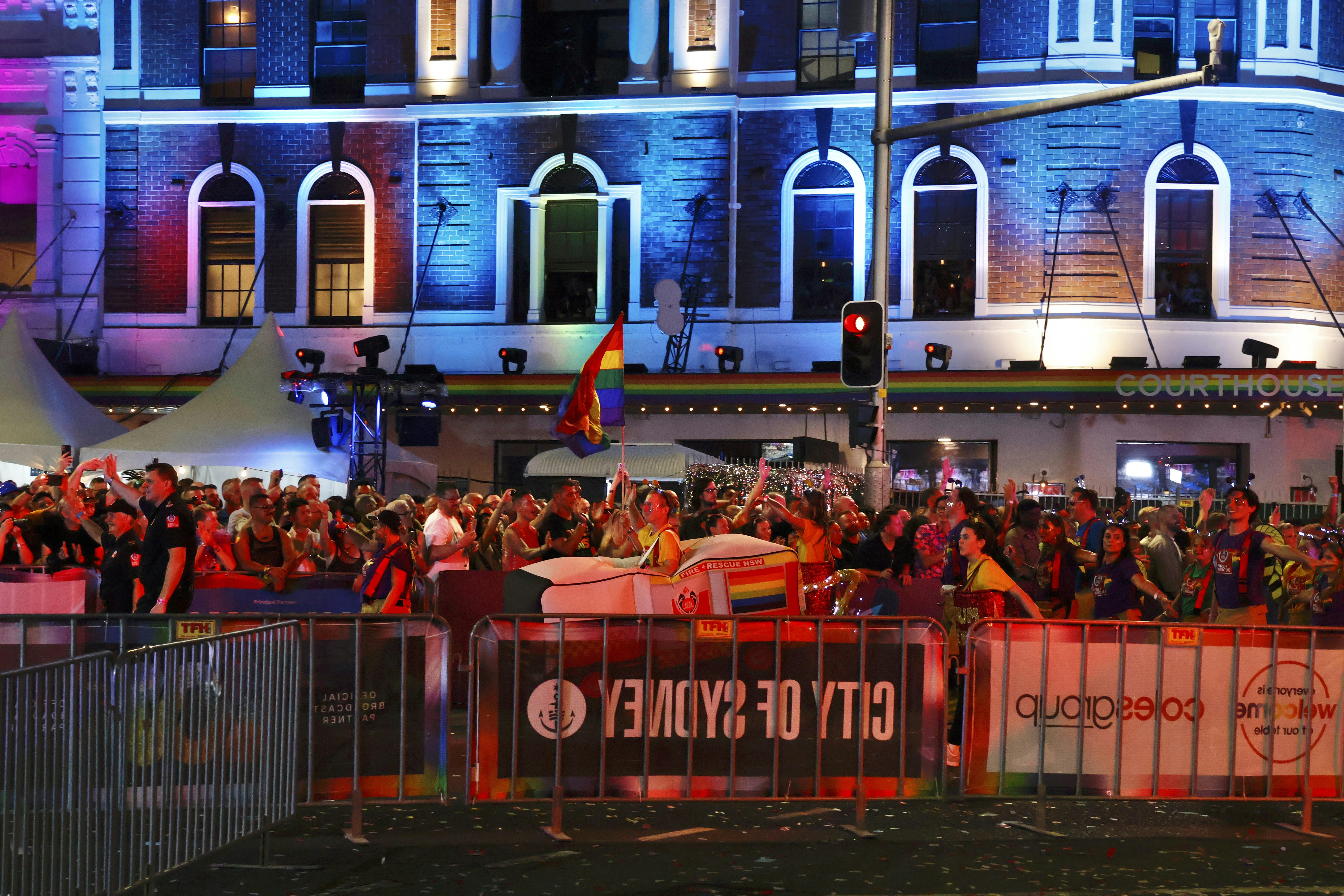 Foule célébrant lors d’un festival avec des drapeaux arc-en-ciel