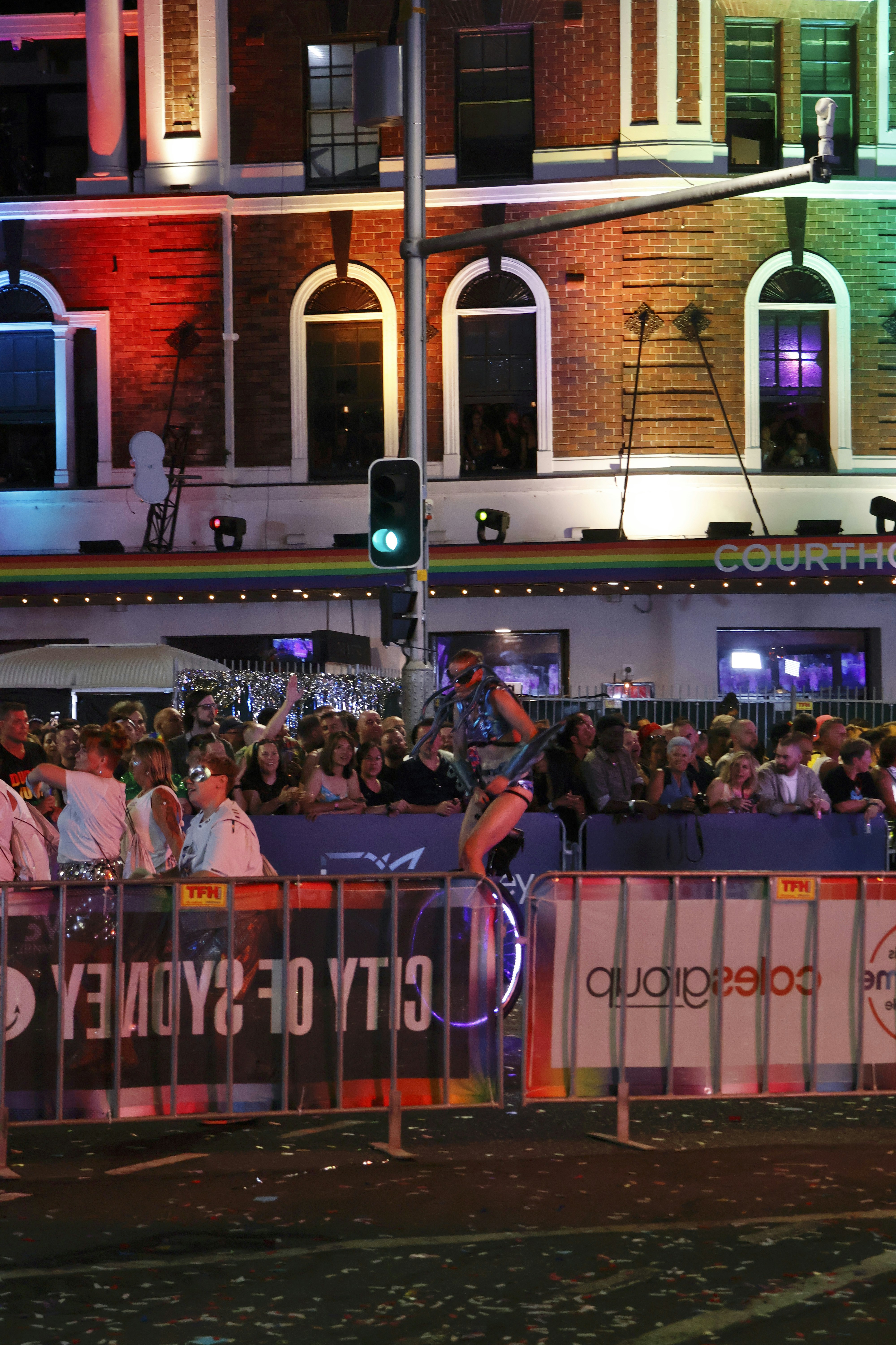 Person rides unicycle at colorful illuminated city event