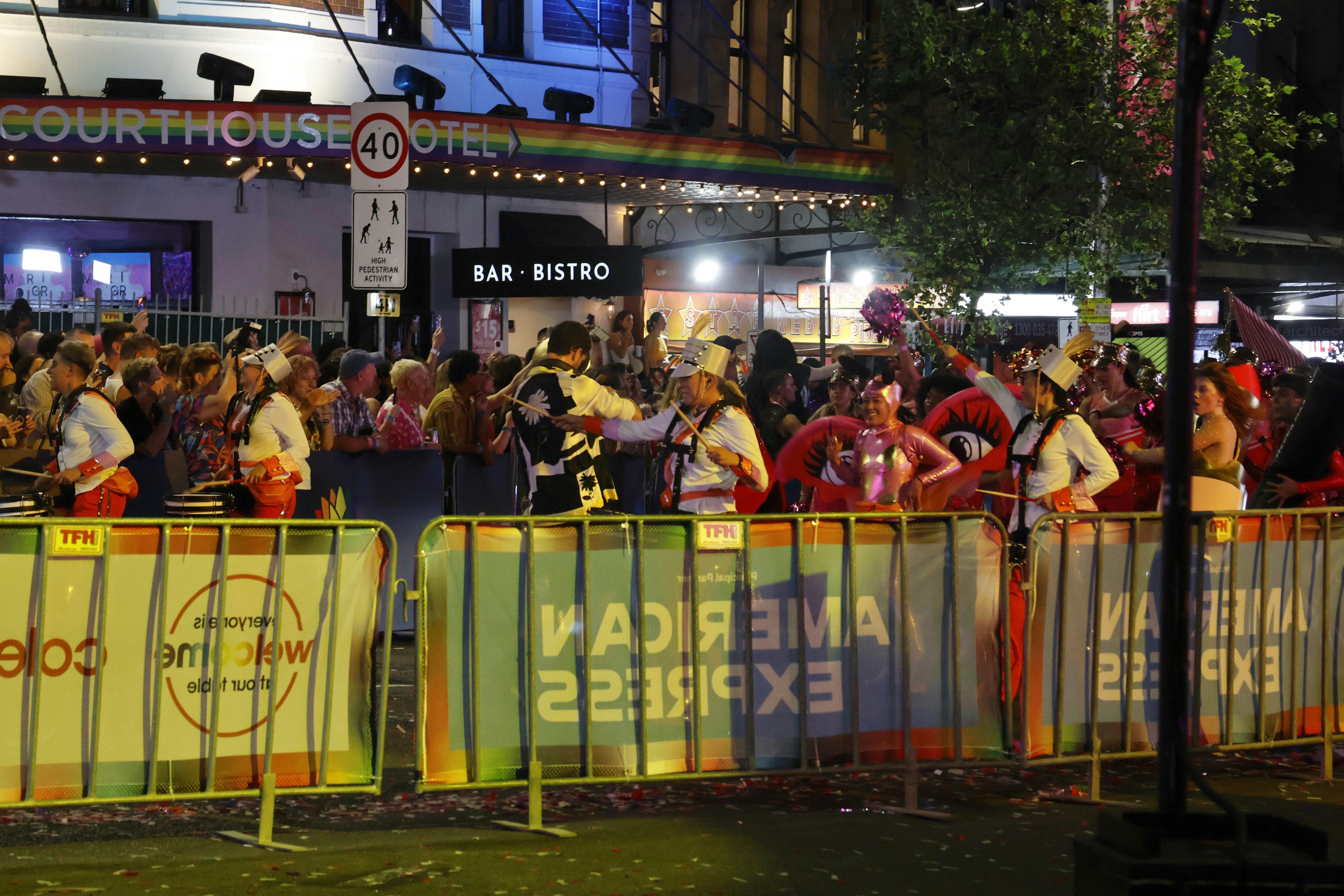 Crowd gathered at night with building and barriers