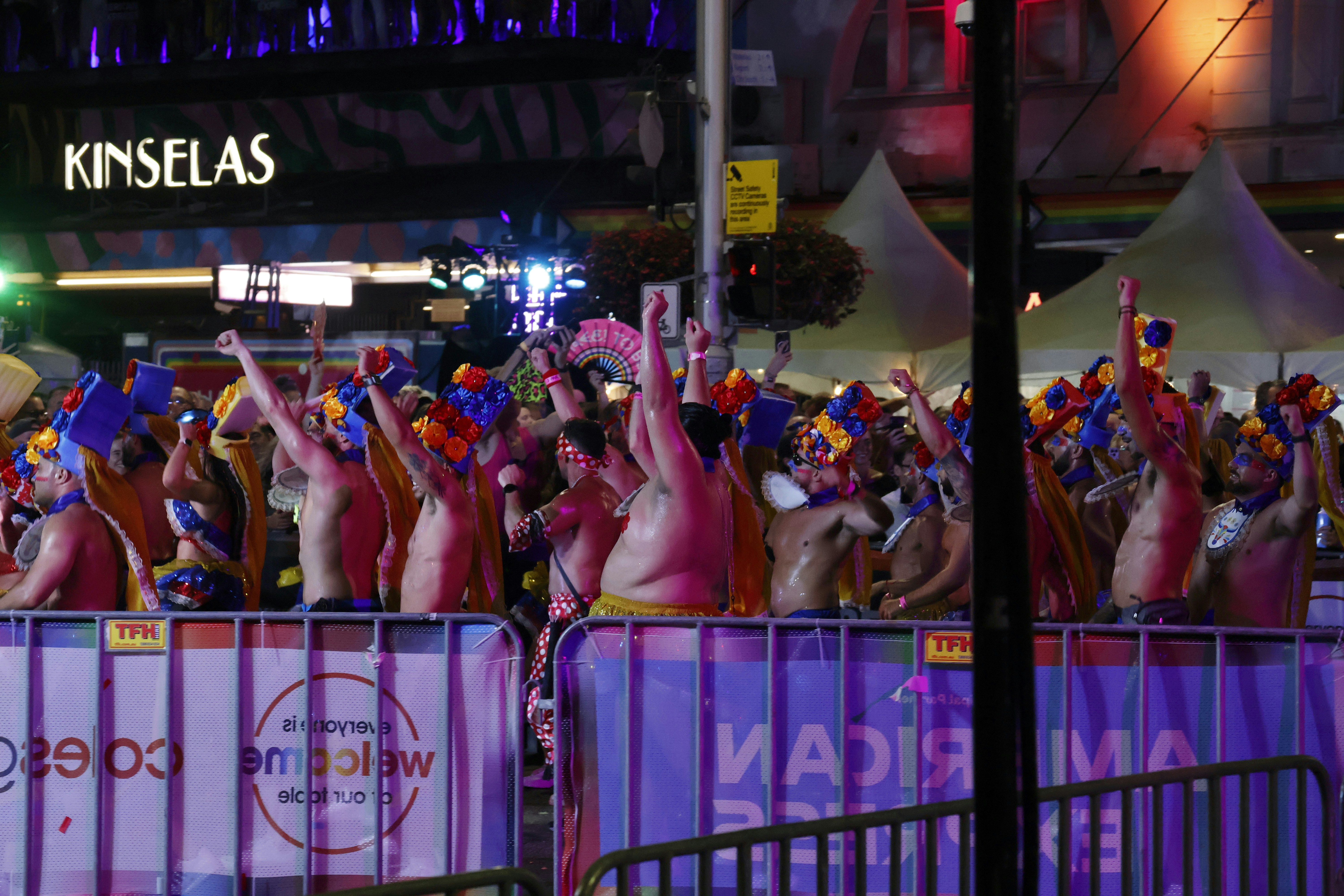 Crowd with hands raised at a vibrant night event.