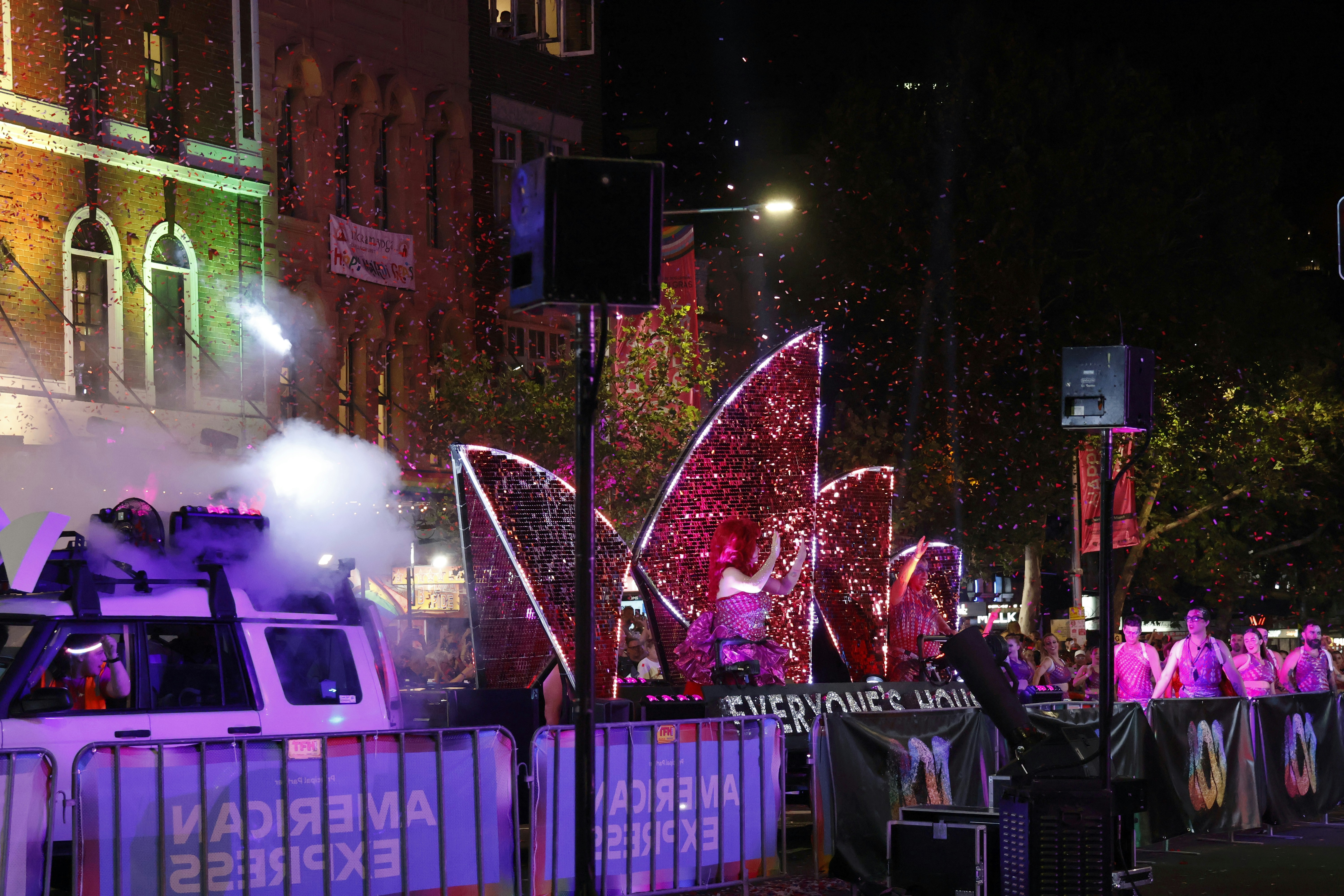 A parade float with confetti and lights at night.