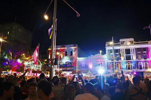 Crowd celebrating at a vibrant, illuminated city festival at night